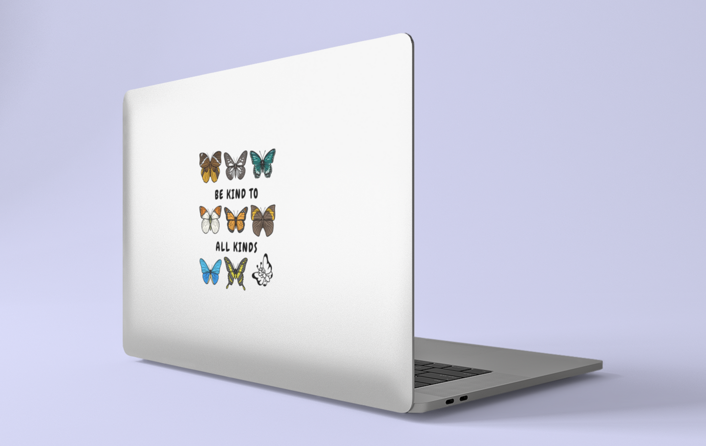 Laptop with a large "be kind to all kinds" butterfly sticker on a light purple background