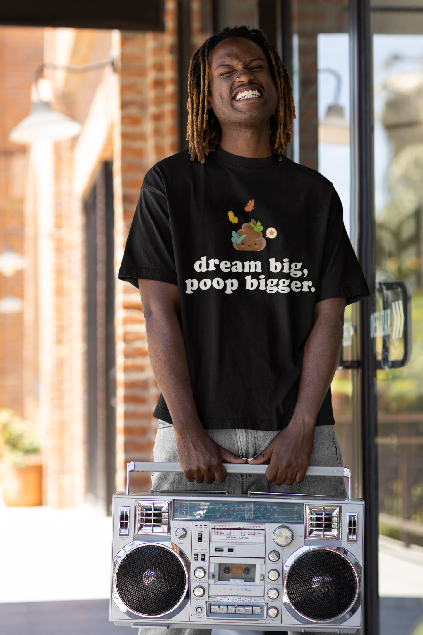 happy male fashion model holding a retro boombox and wearing a "dream big poop bigger" motivational poop back t-shirt
