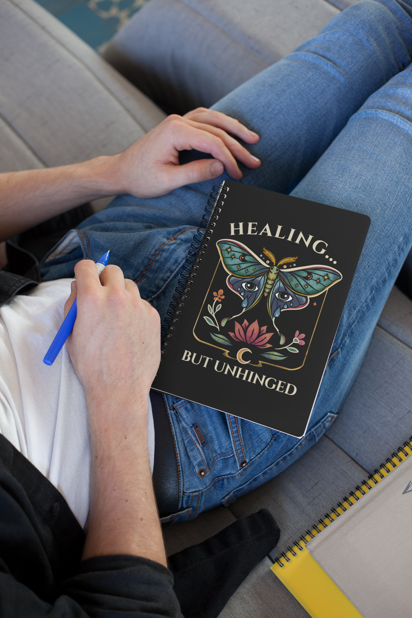 man writing in eco-friendly luna moth affirmation spiral notebook