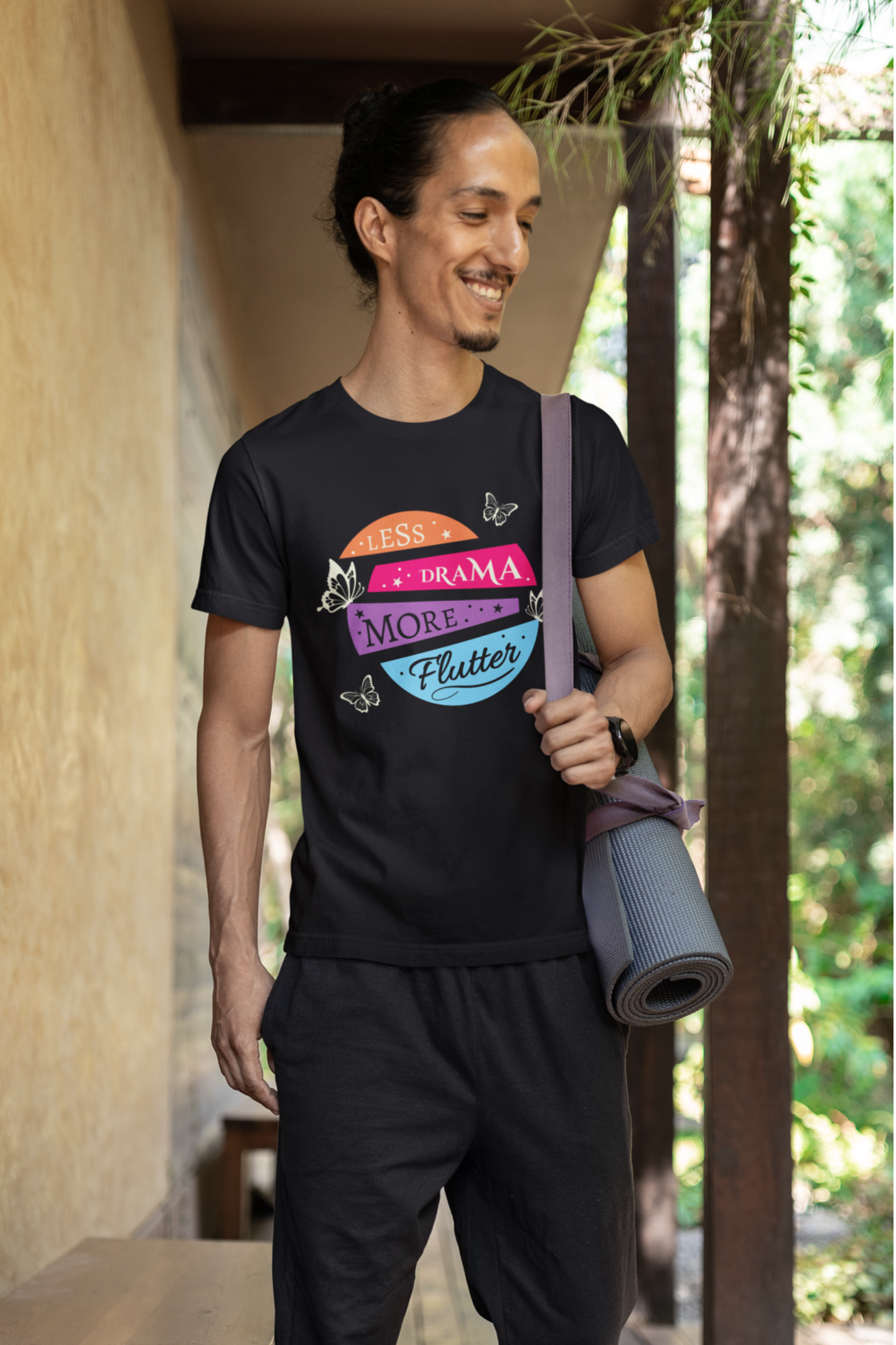 cheerful male fashion model going to a yoga class wearing a black βless drama more flutterβ butterfly t-shirt