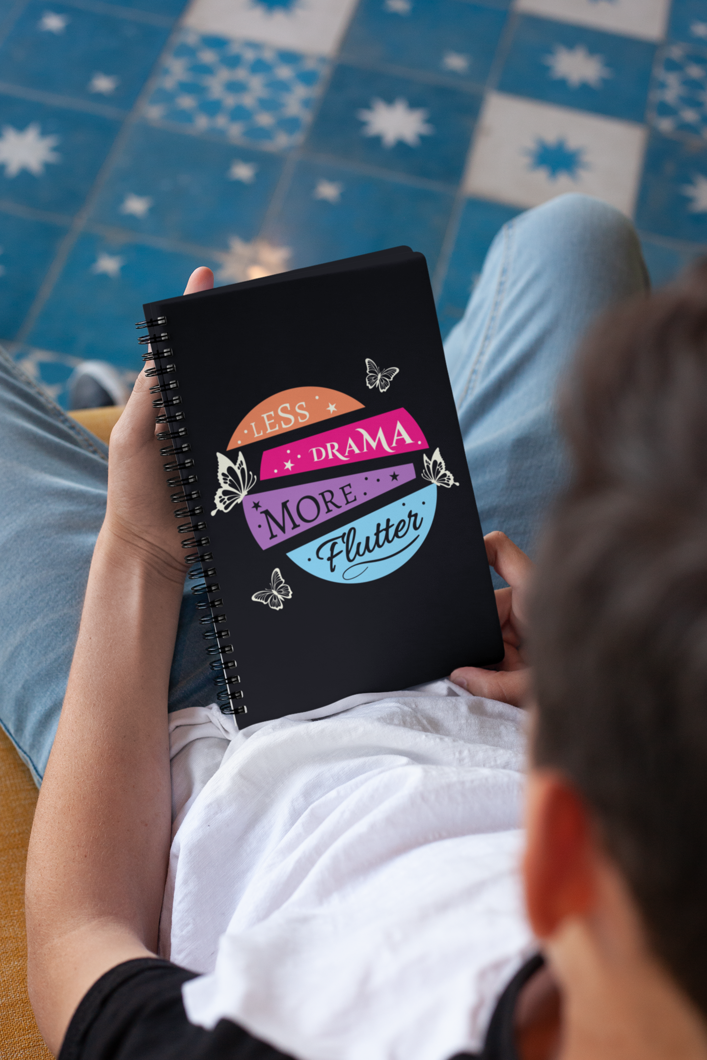 Man holding a 'less drama more flutter' butterfly spiral notebook 6x8