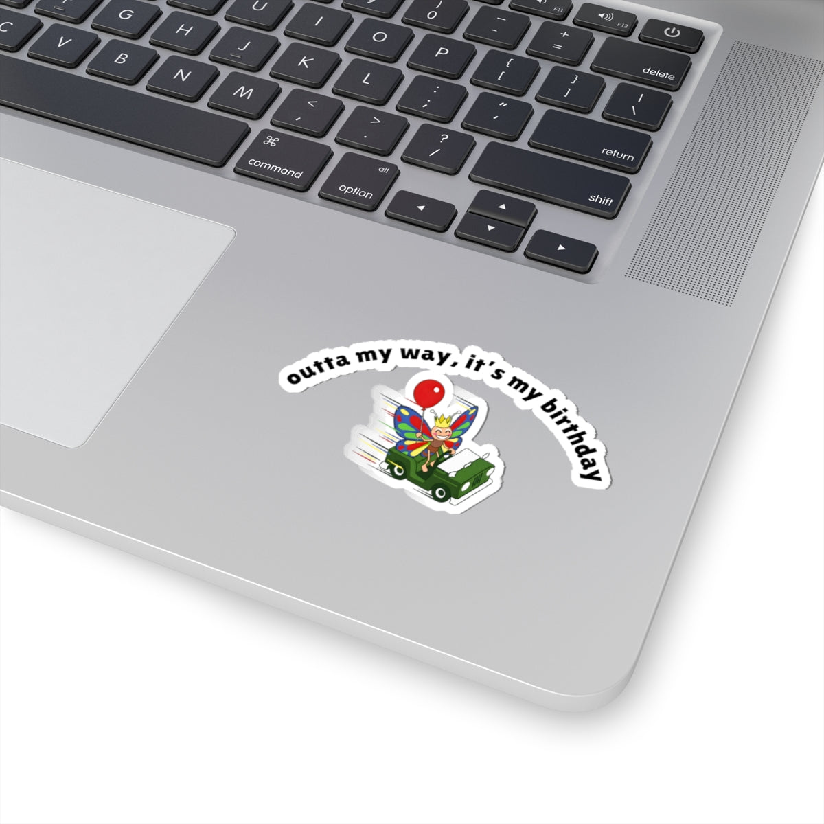 Colorful butterfly birthday vinyl sticker featuring the phrase "Outta My Way, It's My Birthday" applied to the palm rest area of a silver laptop, showcasing a fun decorative sticker for laptops, notebooks, and personal accessories.
