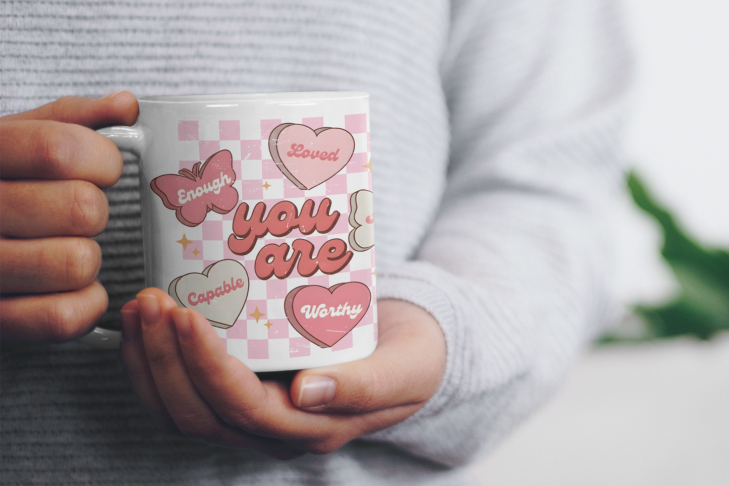 Hands holding a butterfly affirmation mug with hearts and positive message, perfect for Valentine’s Day, self love, and mental health encouragement