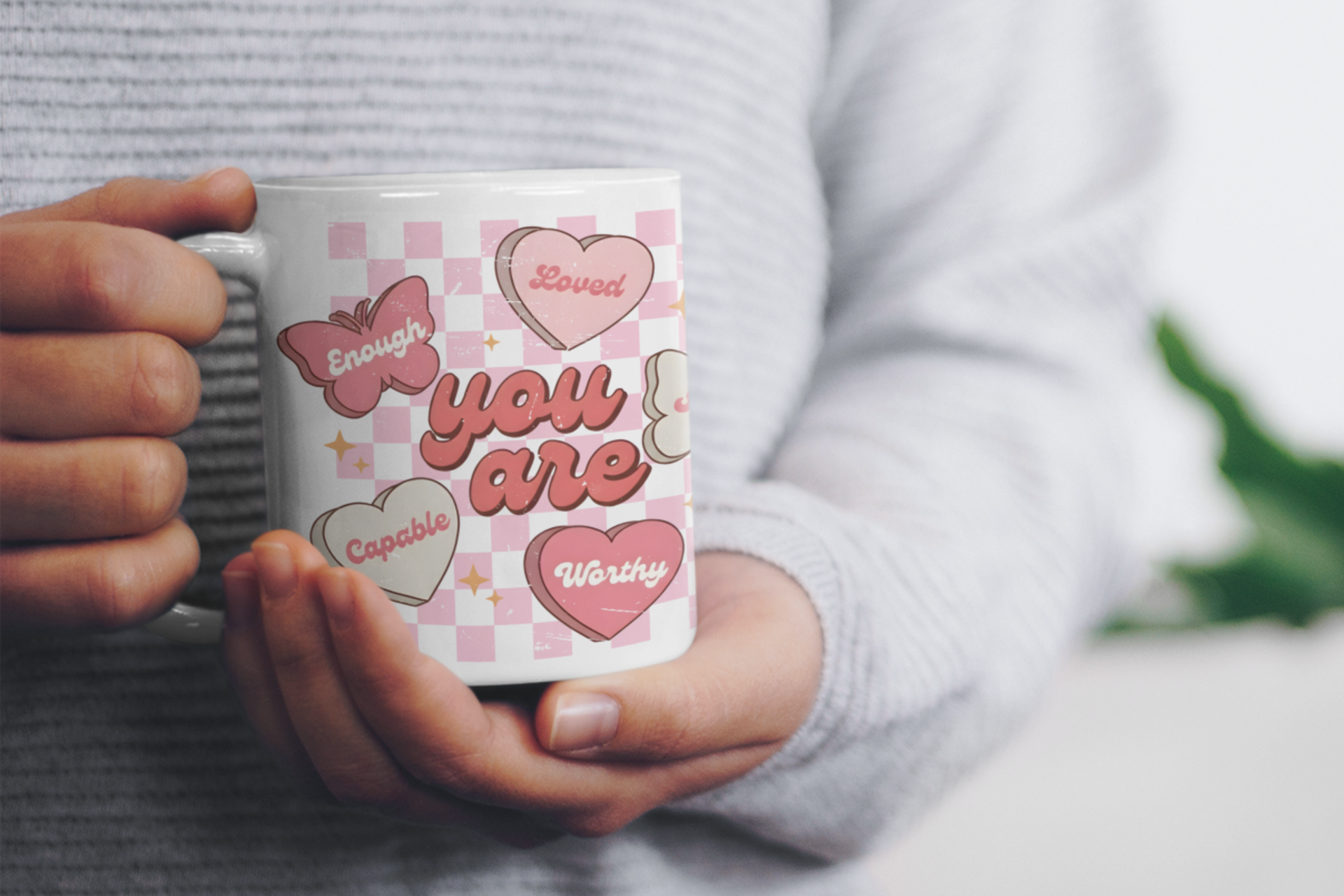 Hands holding a butterfly affirmation mug with hearts and positive message, perfect for Valentine’s Day, self love, and mental health encouragement
