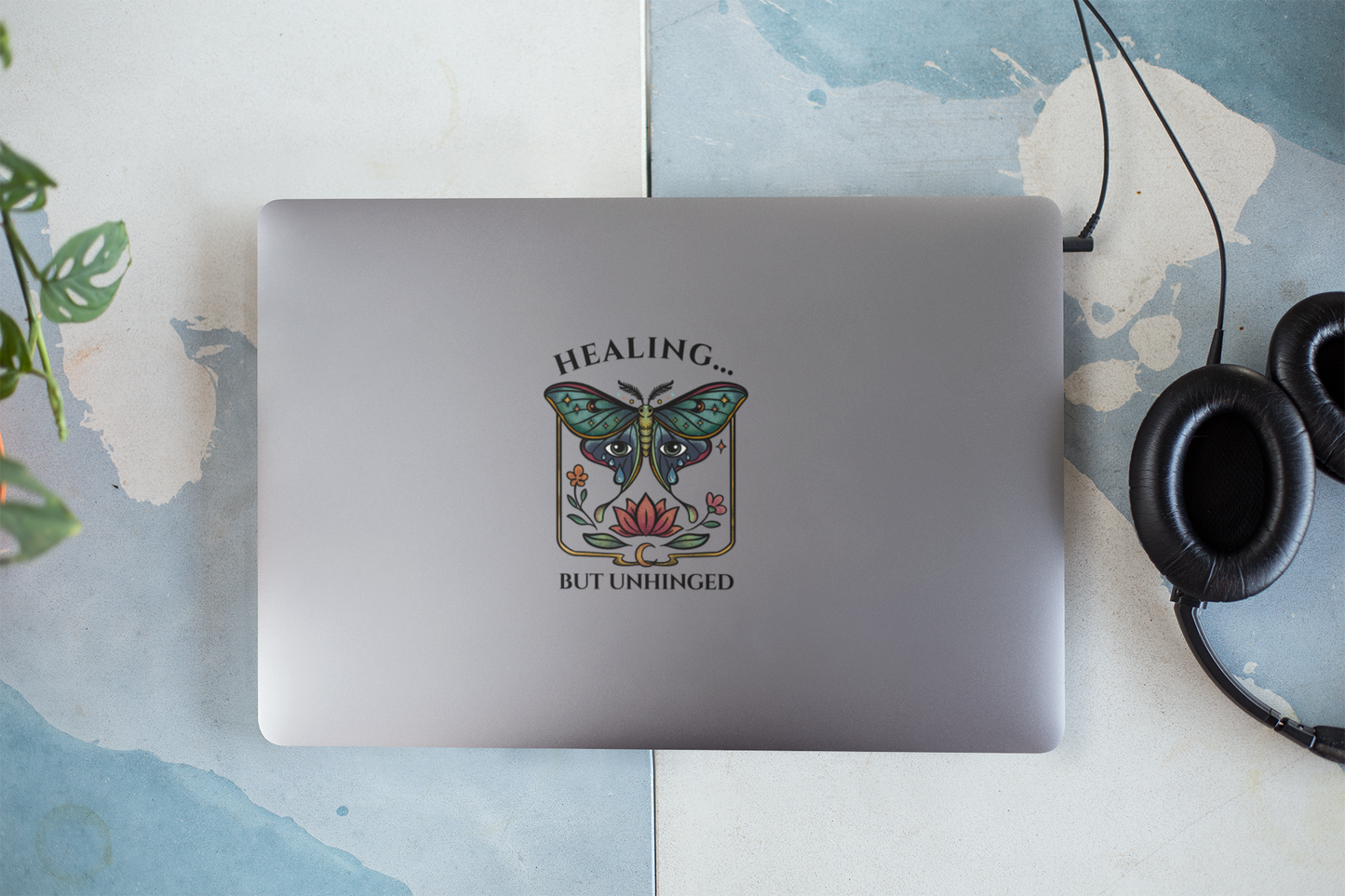laptop with a butterfly design and text on a textured surface