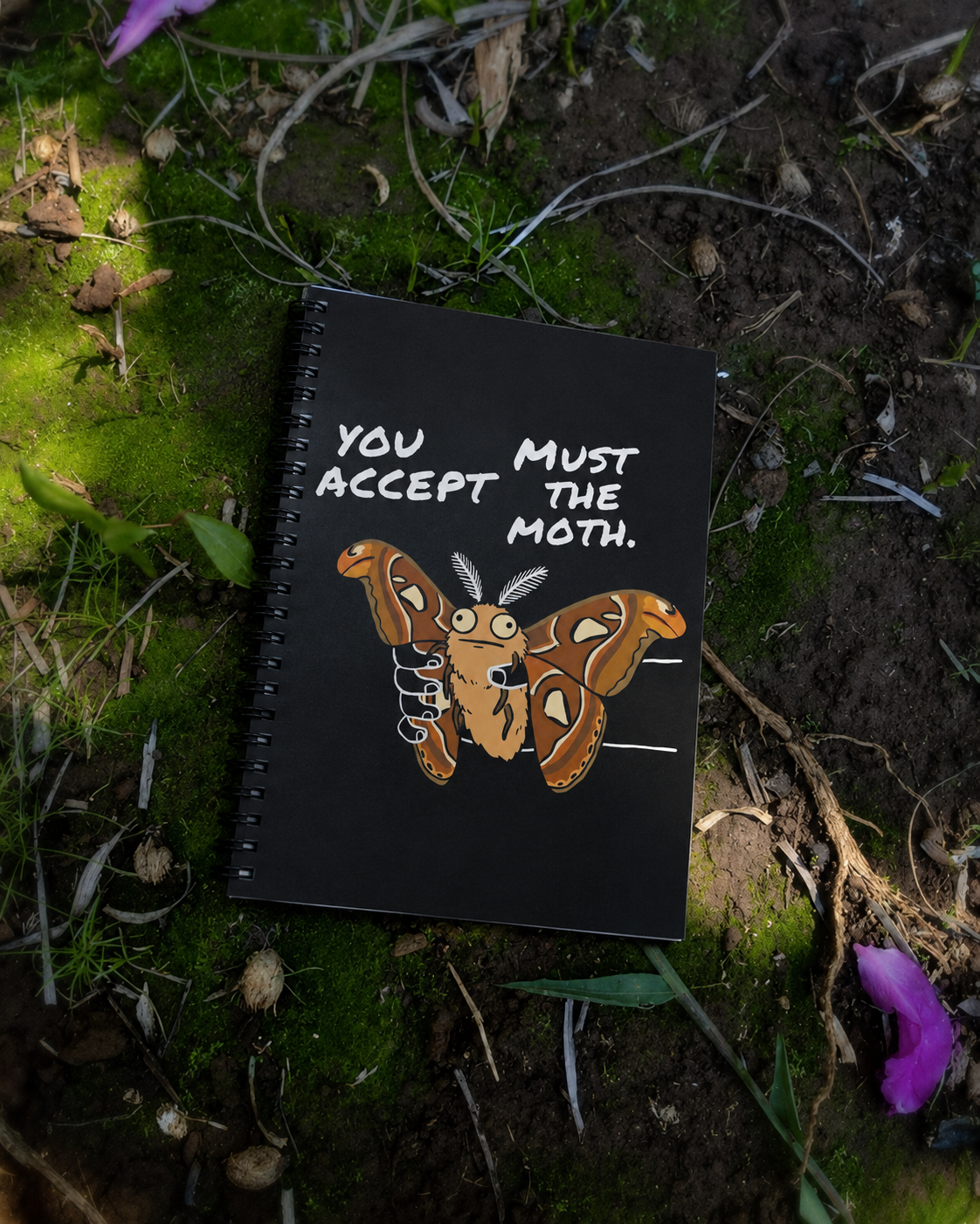 You Must Accept The Moth Atlas Moth notebook lying on mossy ground outdoors