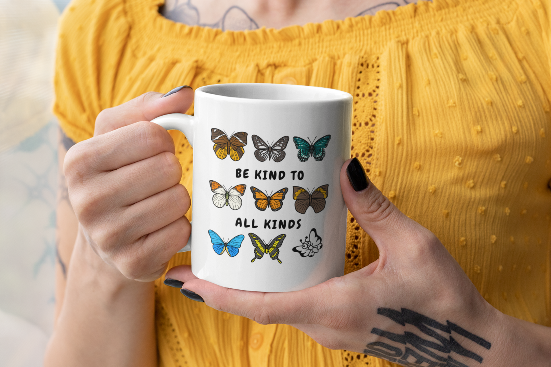 woman holding a "be kind to all kinds" butterflies mug against a yellow textured background