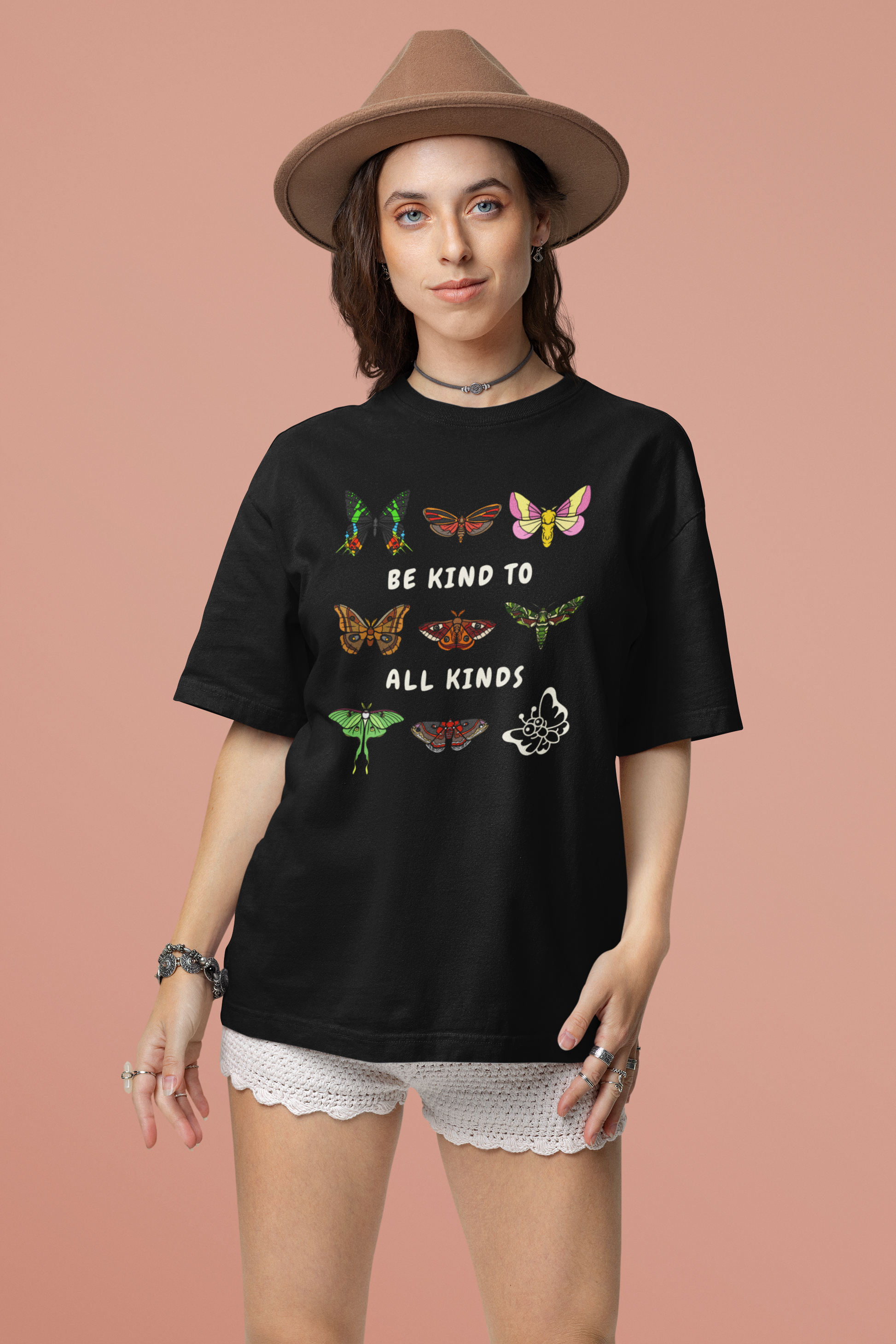 black 'be kind to all kinds' butterflies tee on model with a boho style and peach background