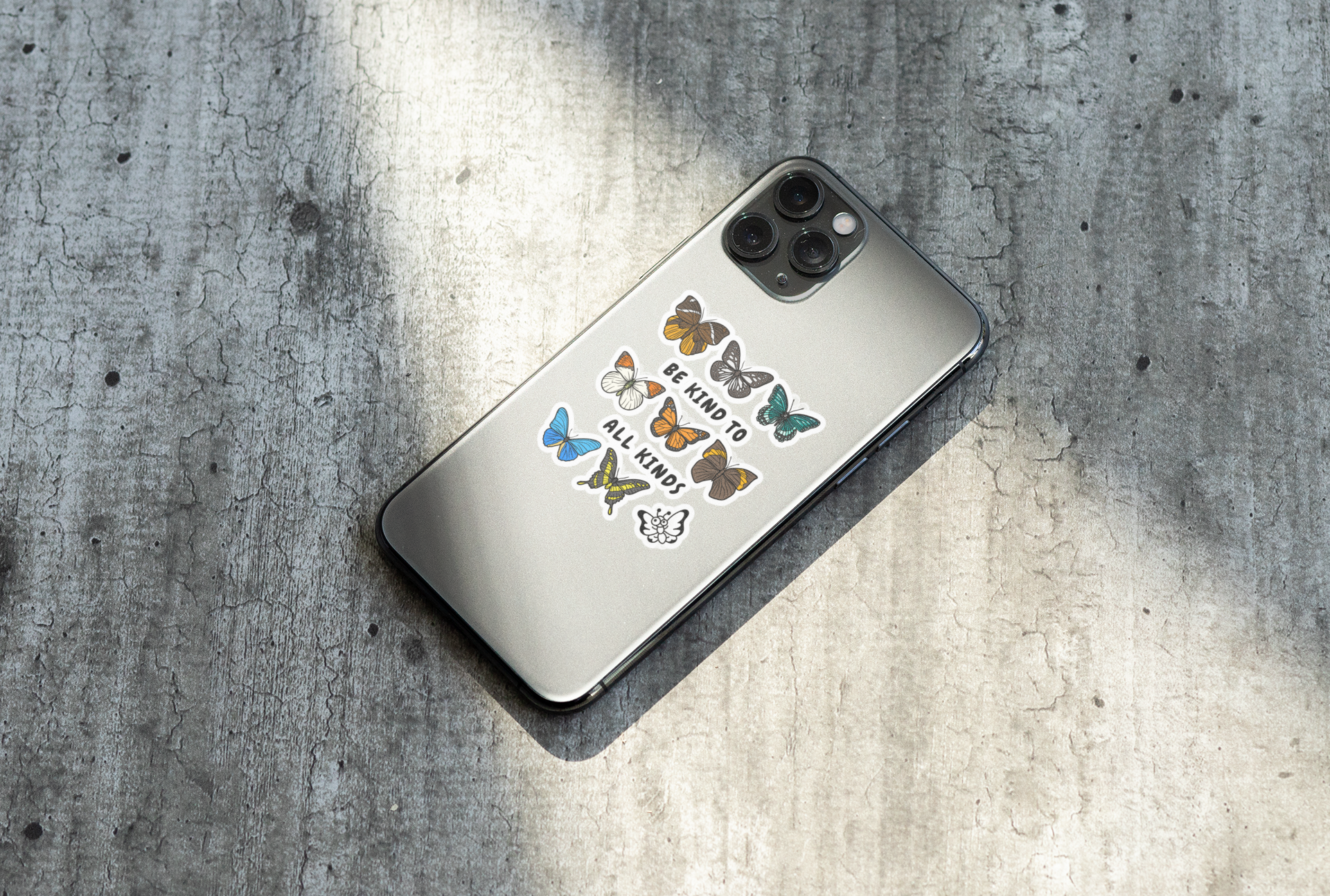 moths and butterflies kindness sticker on a phone case over a textured surface