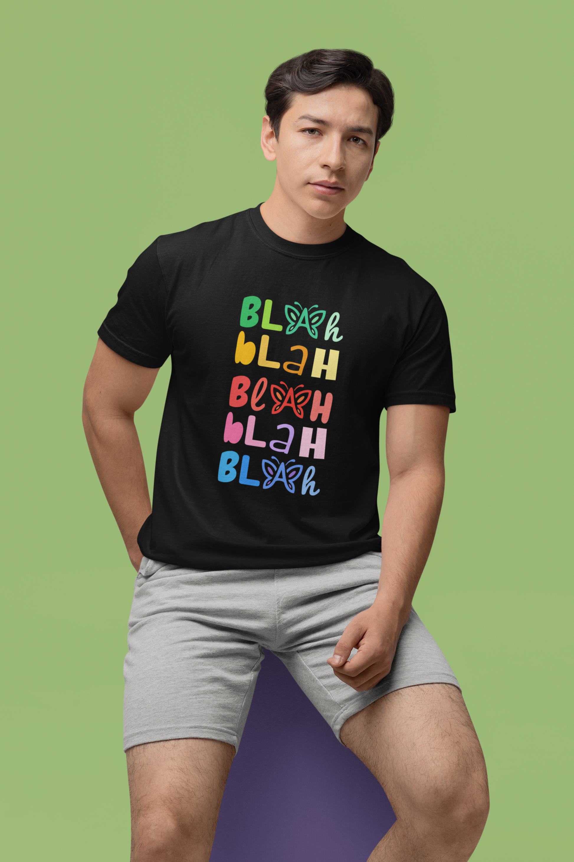 Man wearing a black “Blah Blah Blah” butterfly t-shirt on a green background