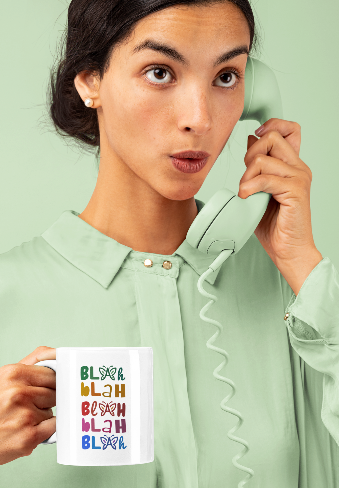 Woman holding a colorful “Blah Blah Blah” white mug against a light green background