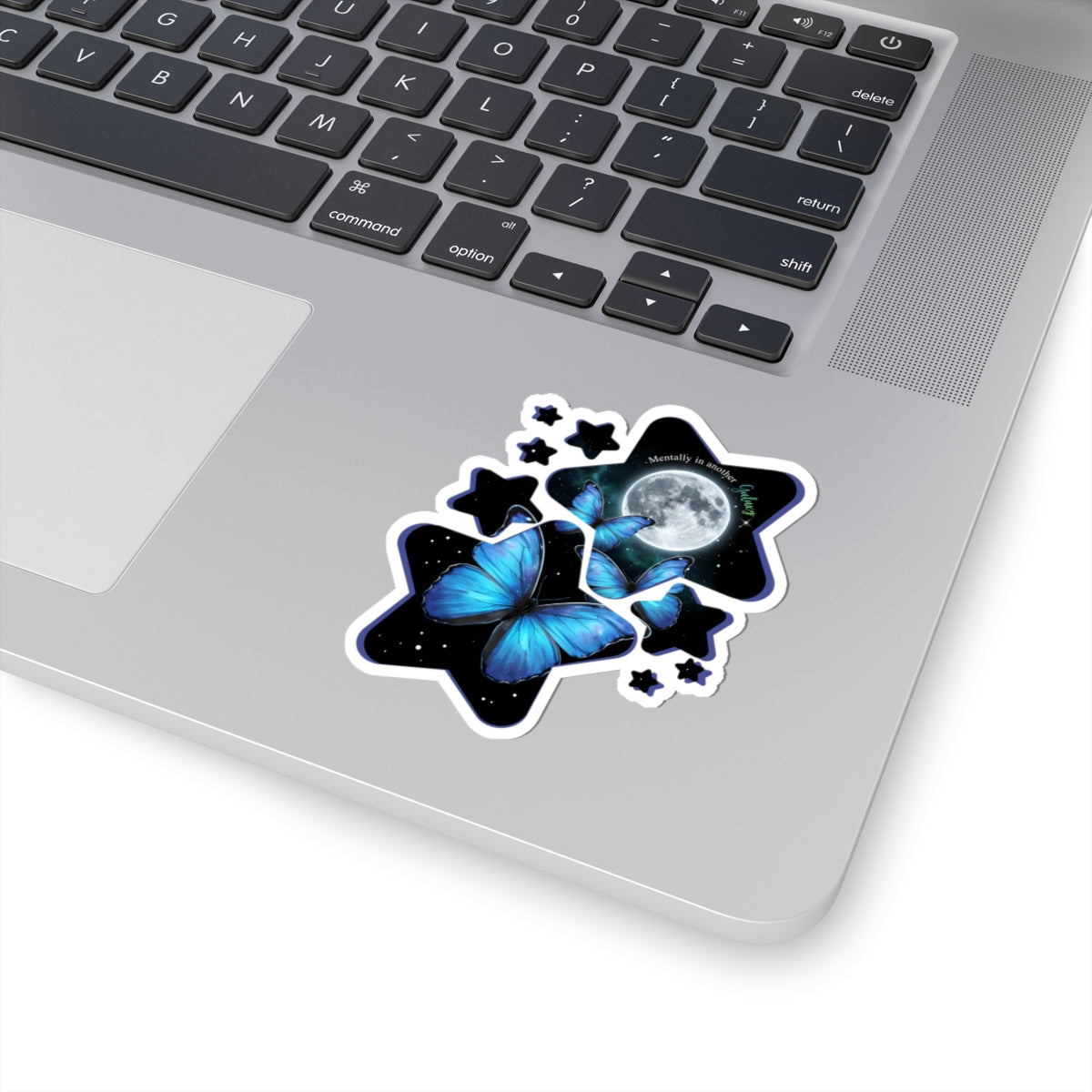 Laptop with a blue morpho butterfly celestial moon and stars vinyl sticker on the palm rest area.