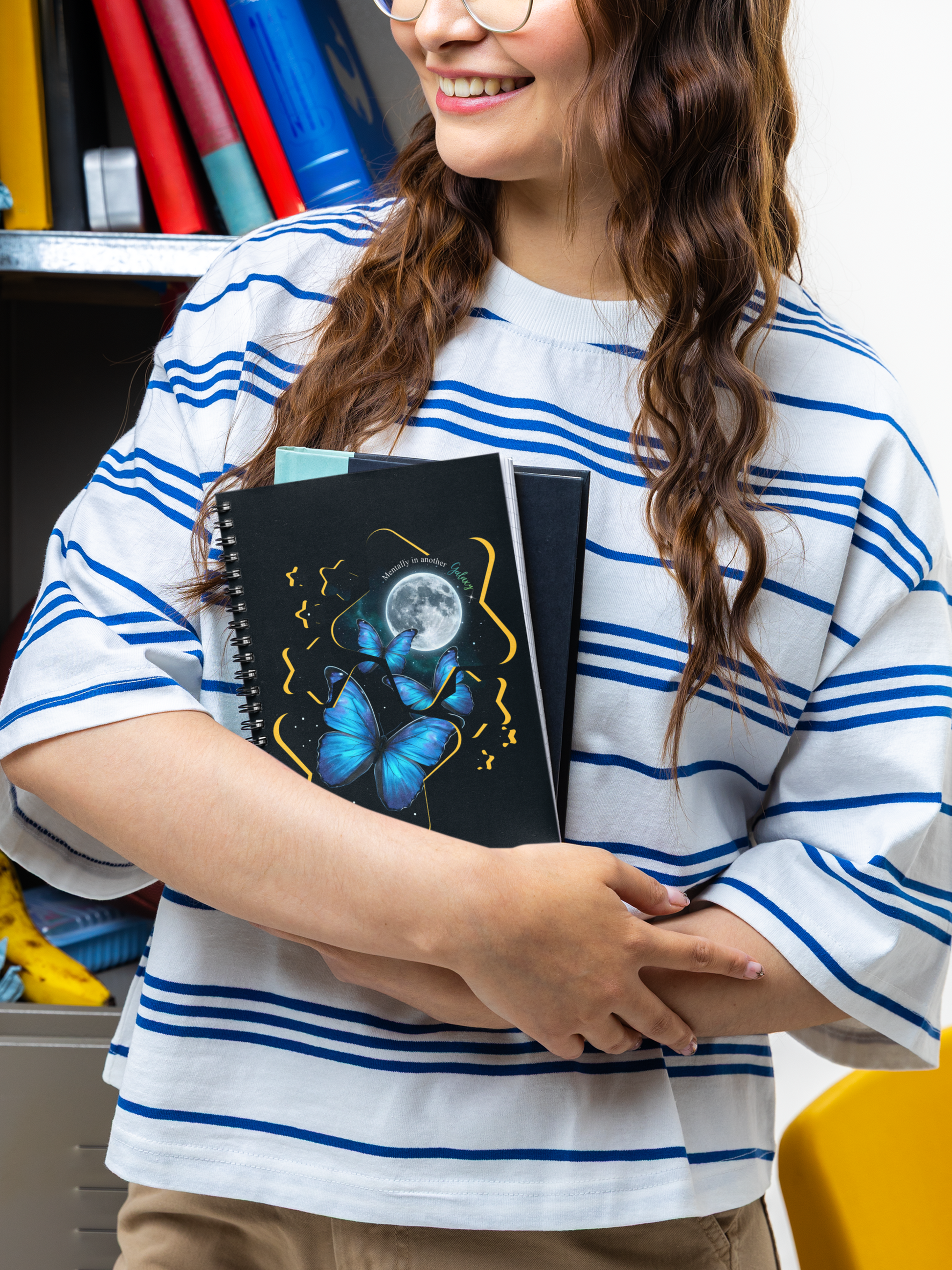 Person holding blue morpho butterfly moon and stars celestial spiral notebook in an indoor setting