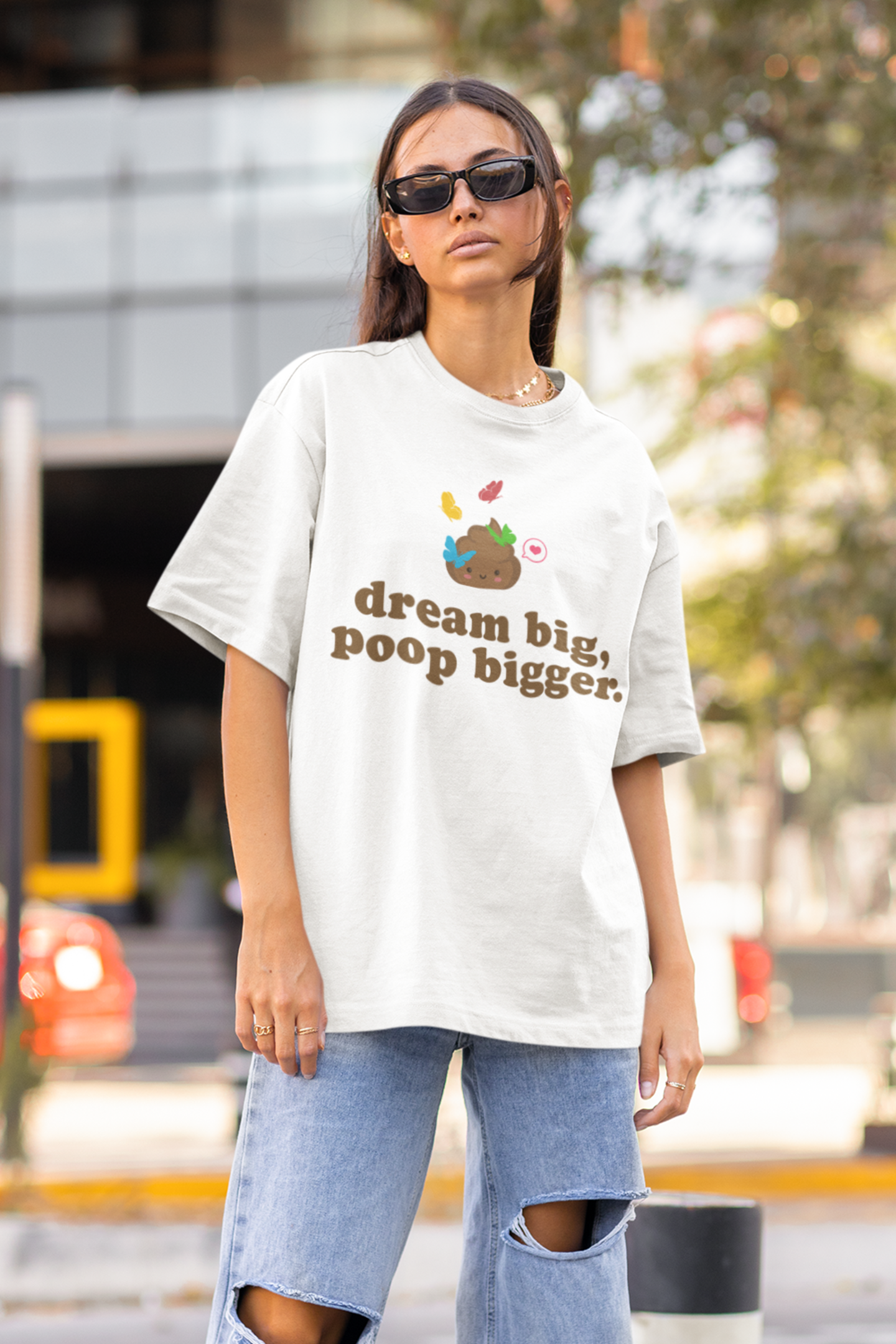 female fashion model with sunglasses wearing a "dream big poop bigger" goals white tee on street and baggy jeans