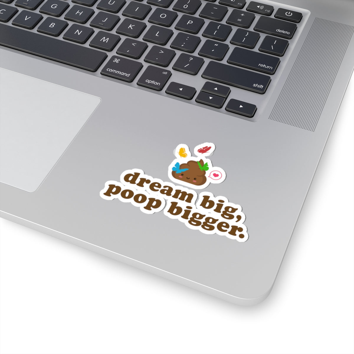 laptop with a funny poop vinyl sticker that reads 'dream big, poop bigger' on the keyboard area