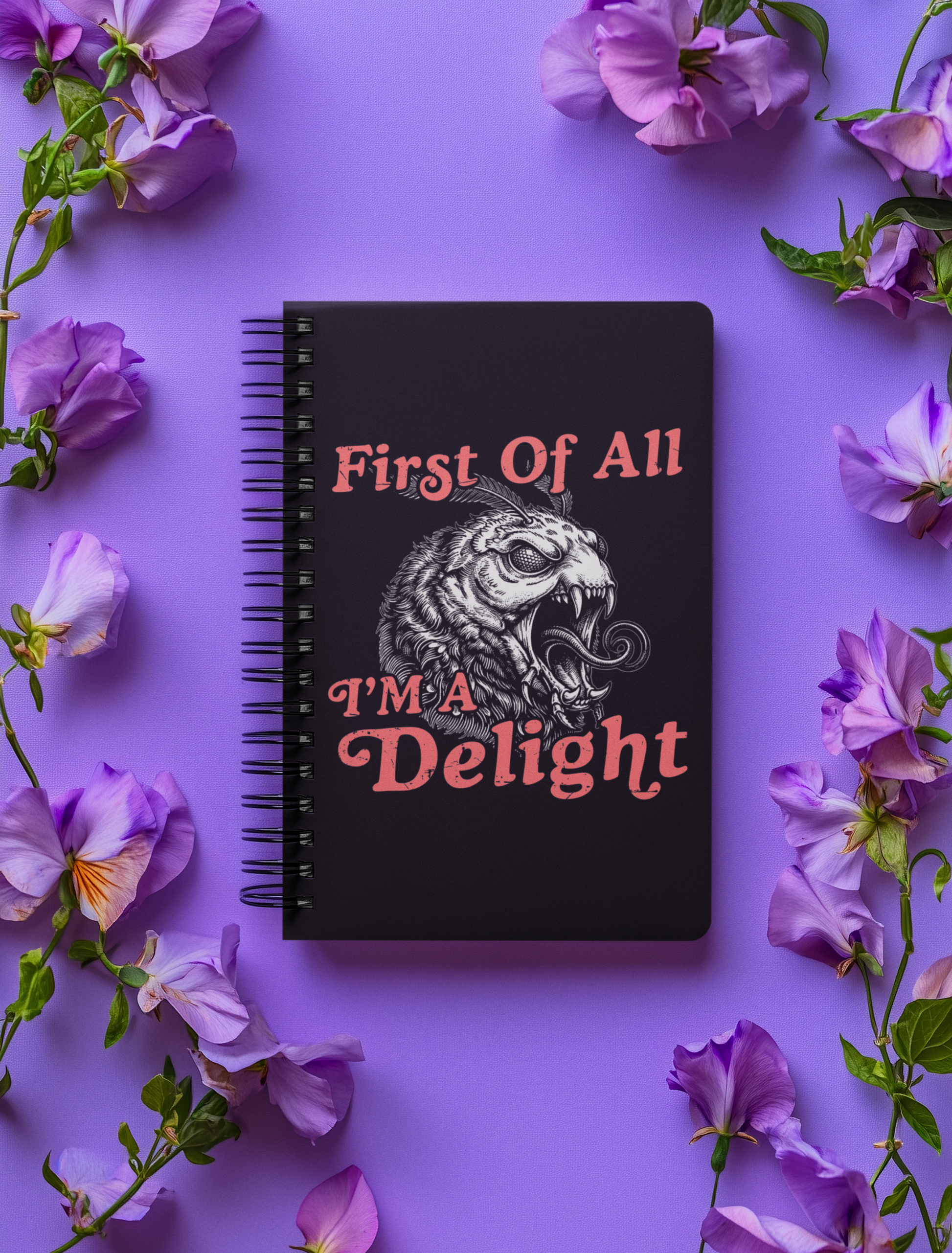 Black First Of All I’m a Delight monster moth notebook styled on a purple background with flowers around it.