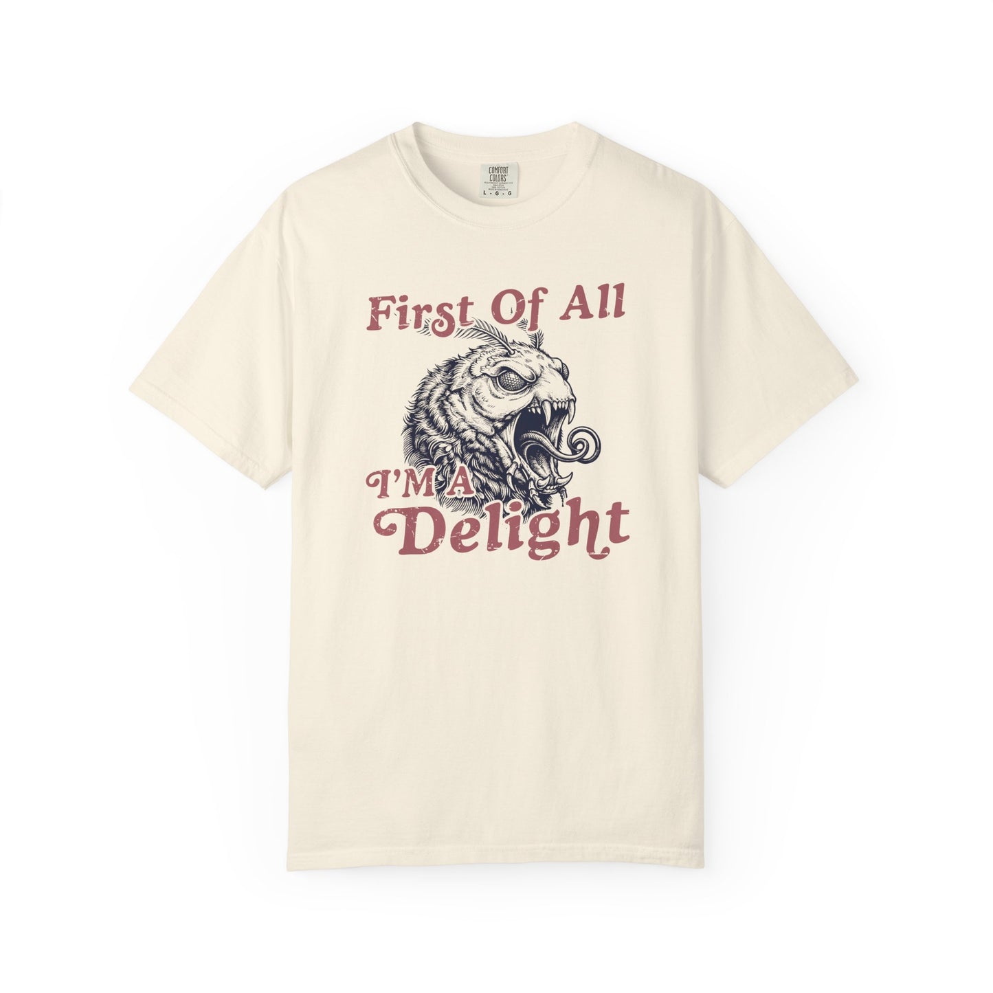 Cream graphic t-shirt with coral vintage lettering and a detailed monster moth design reading First Of All I’m a Delight.