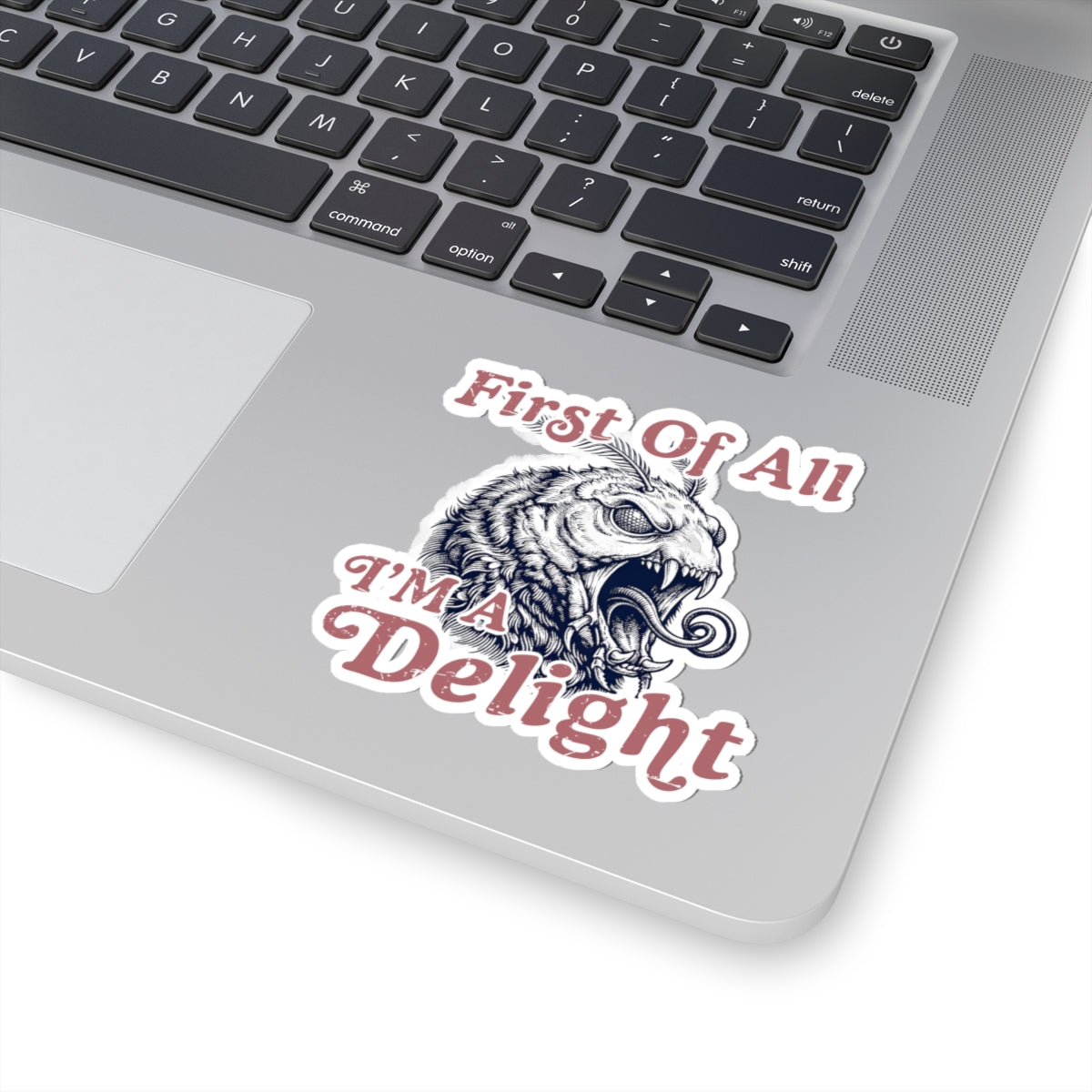 Funny sarcastic monster moth sticker placed on a laptop palm rest below the keyboard.
