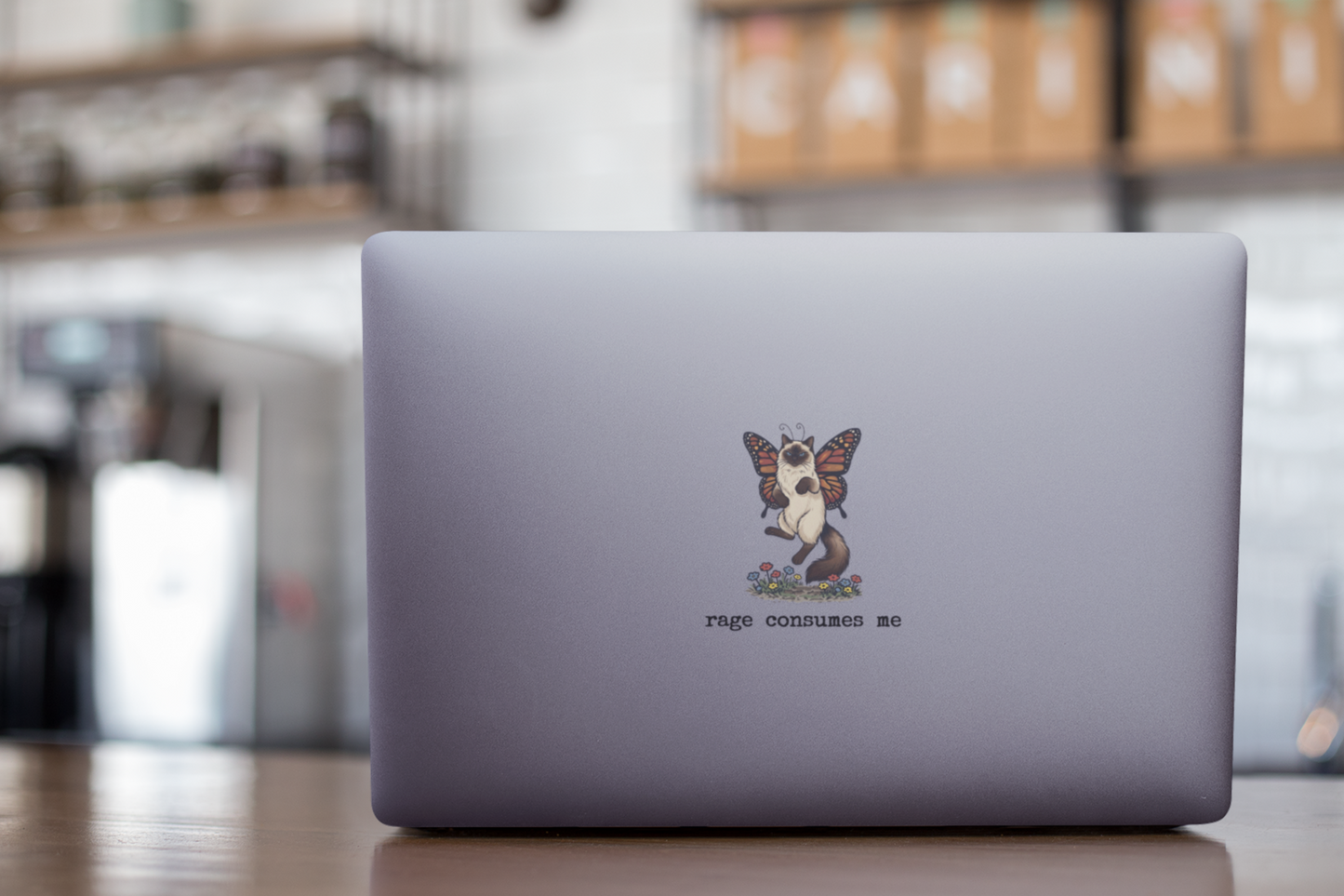 Small Rage Consumes Me cat sticker applied to laptop lid