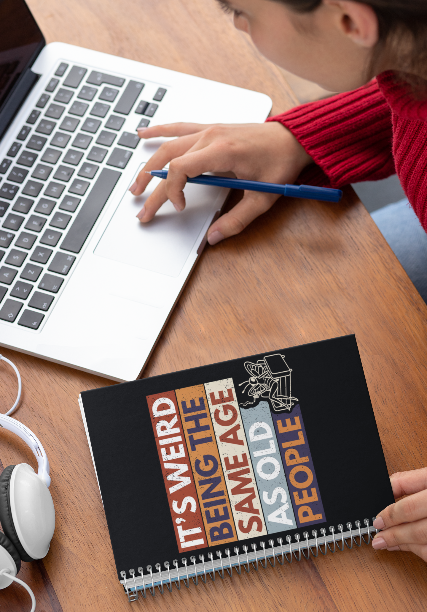 Person using a laptop with a funny butterfly notebook on desk workspace sarcastic aging humor journal.