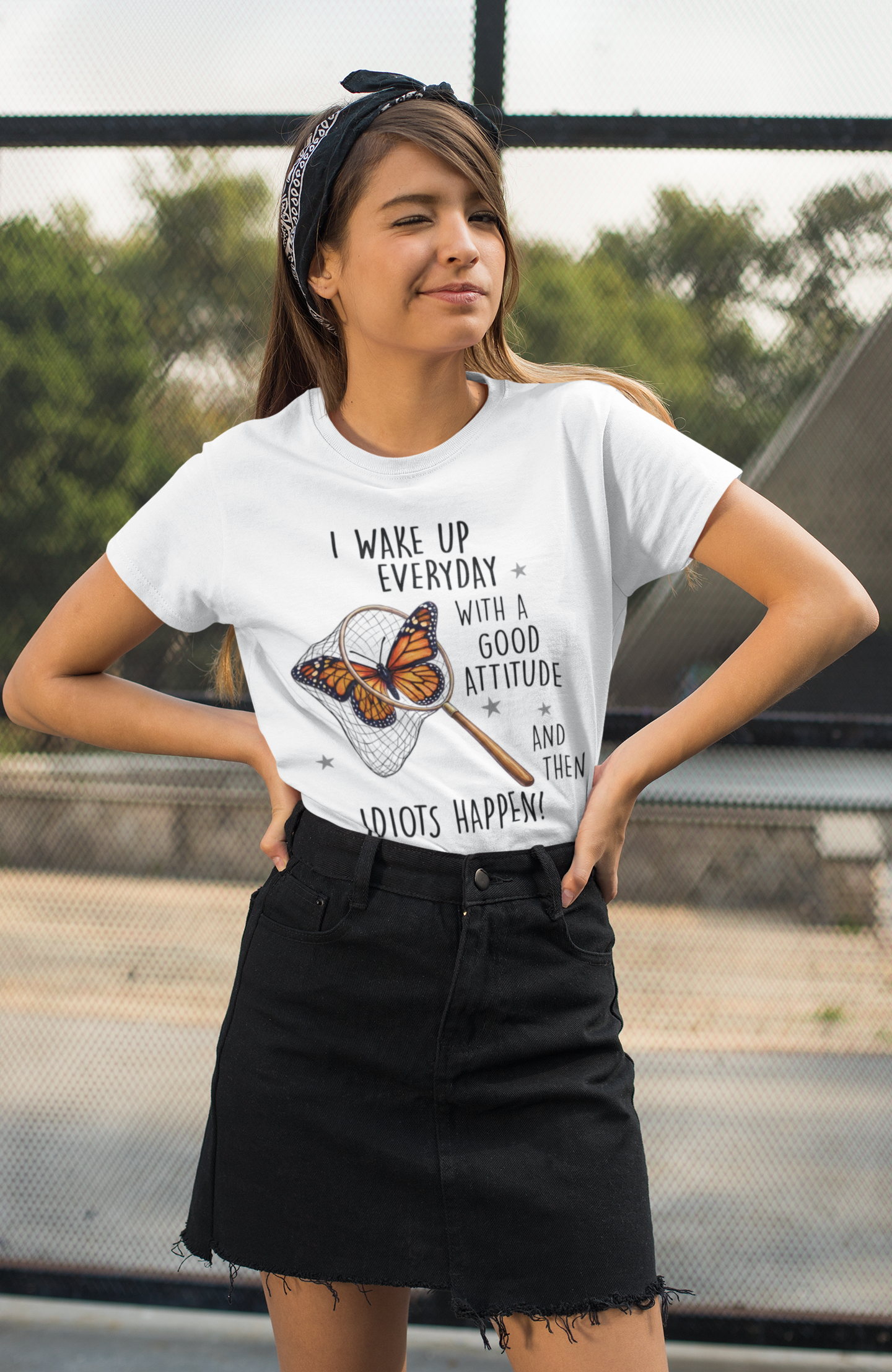 Female model wearing white sarcastic butterfly t-shirt with funny attitude quote, standing outdoors.