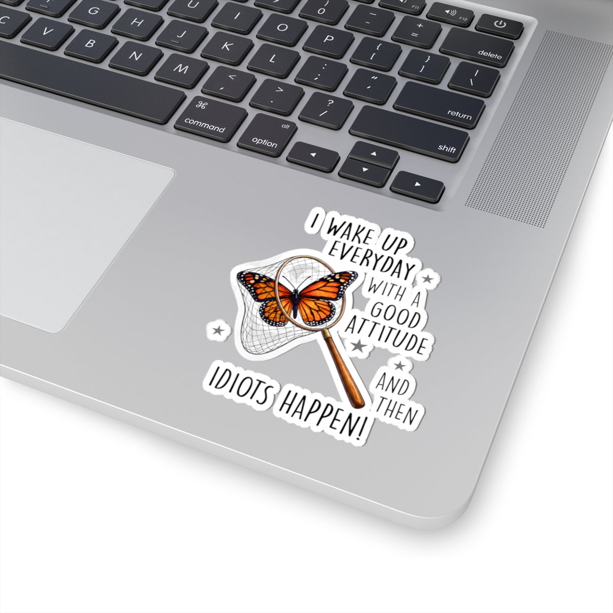 Laptop with a sarcastic butterfly sticker on the palm rest area.