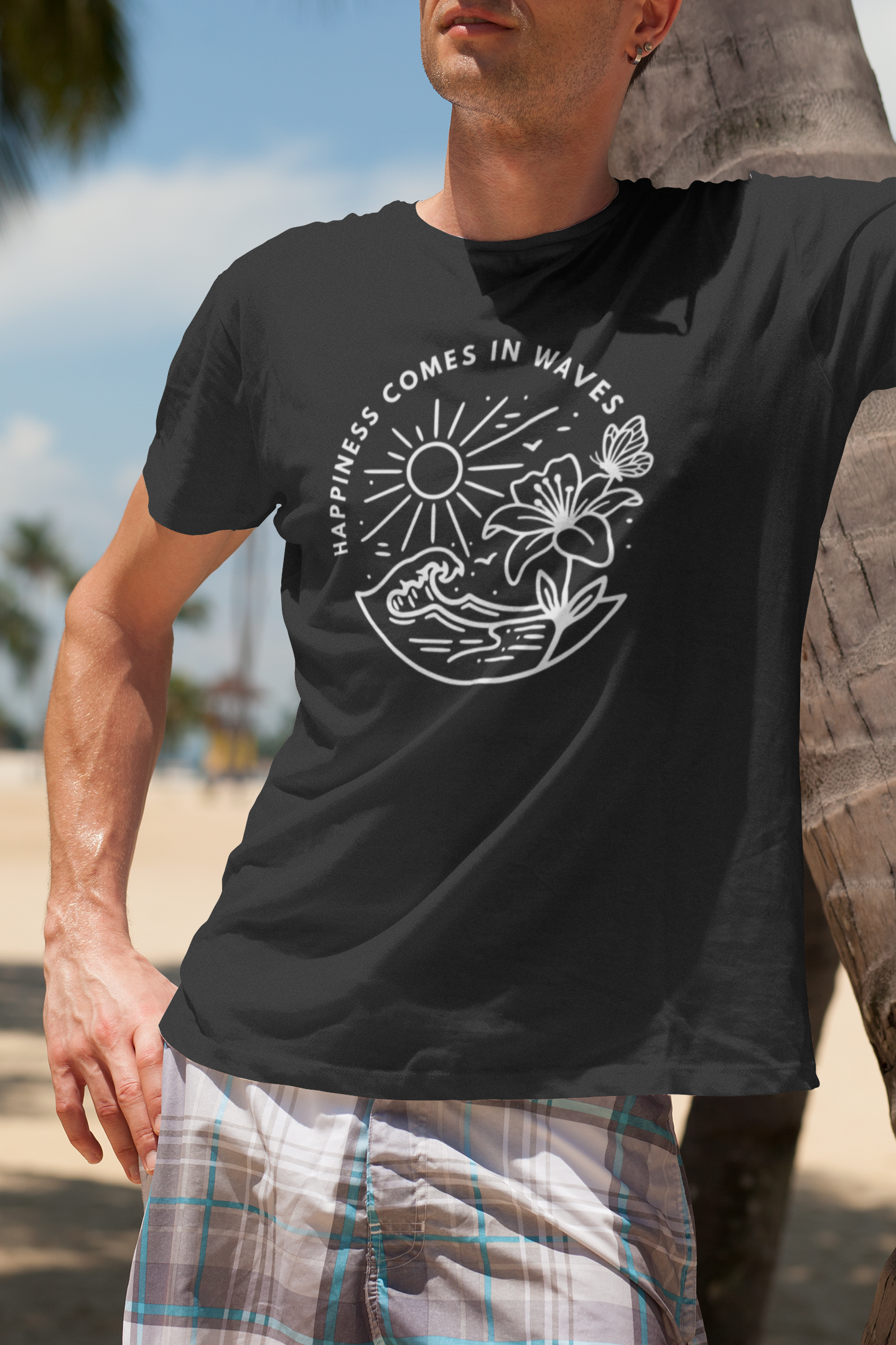 Black Happiness Comes in Waves beach butterfly t-shirt shown on male model outdoors in a tropical vacation on the beach