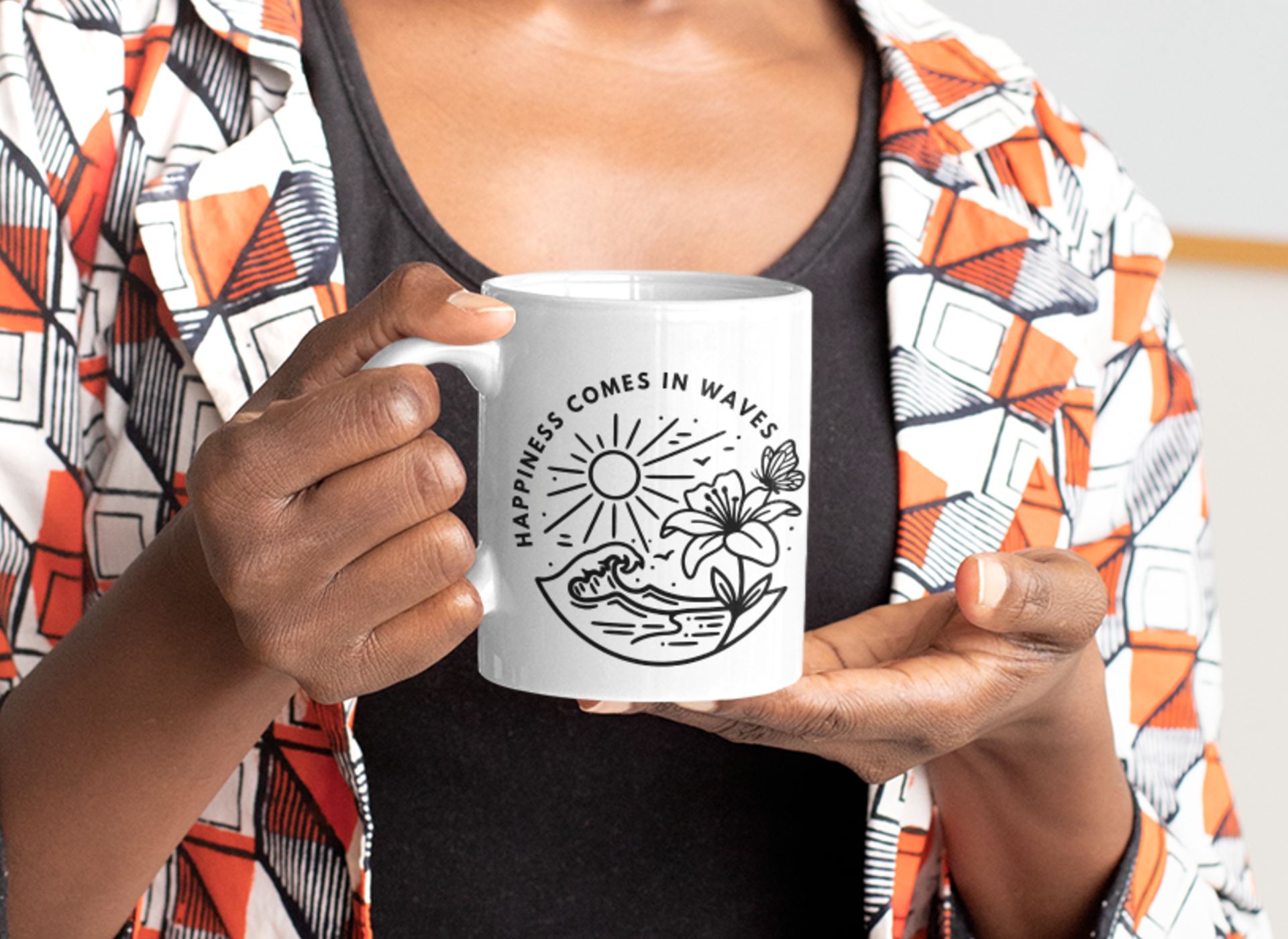 Happiness Comes in Waves beach butterfly mug held by person wearing a colorful patterned shirt.
