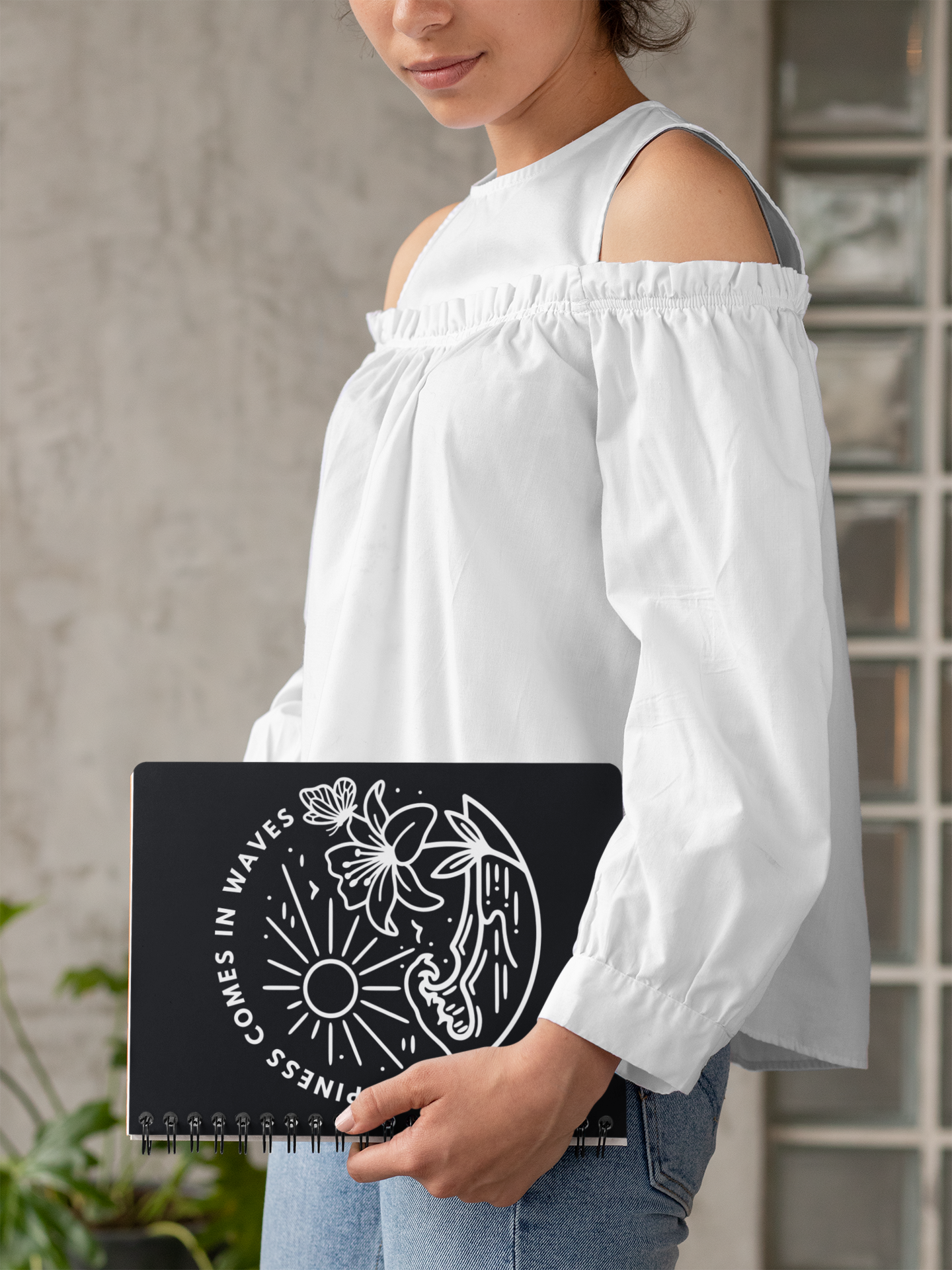 Woman holding Happiness Comes in Waves black beach butterfly notebook in lifestyle photo