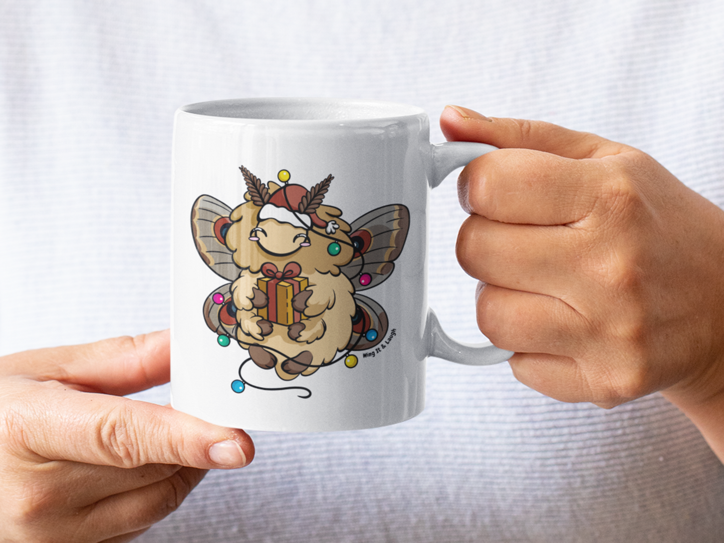 Man wearing a white t-shirt and holding the eco friendly holiday moth Christmas lights mug.