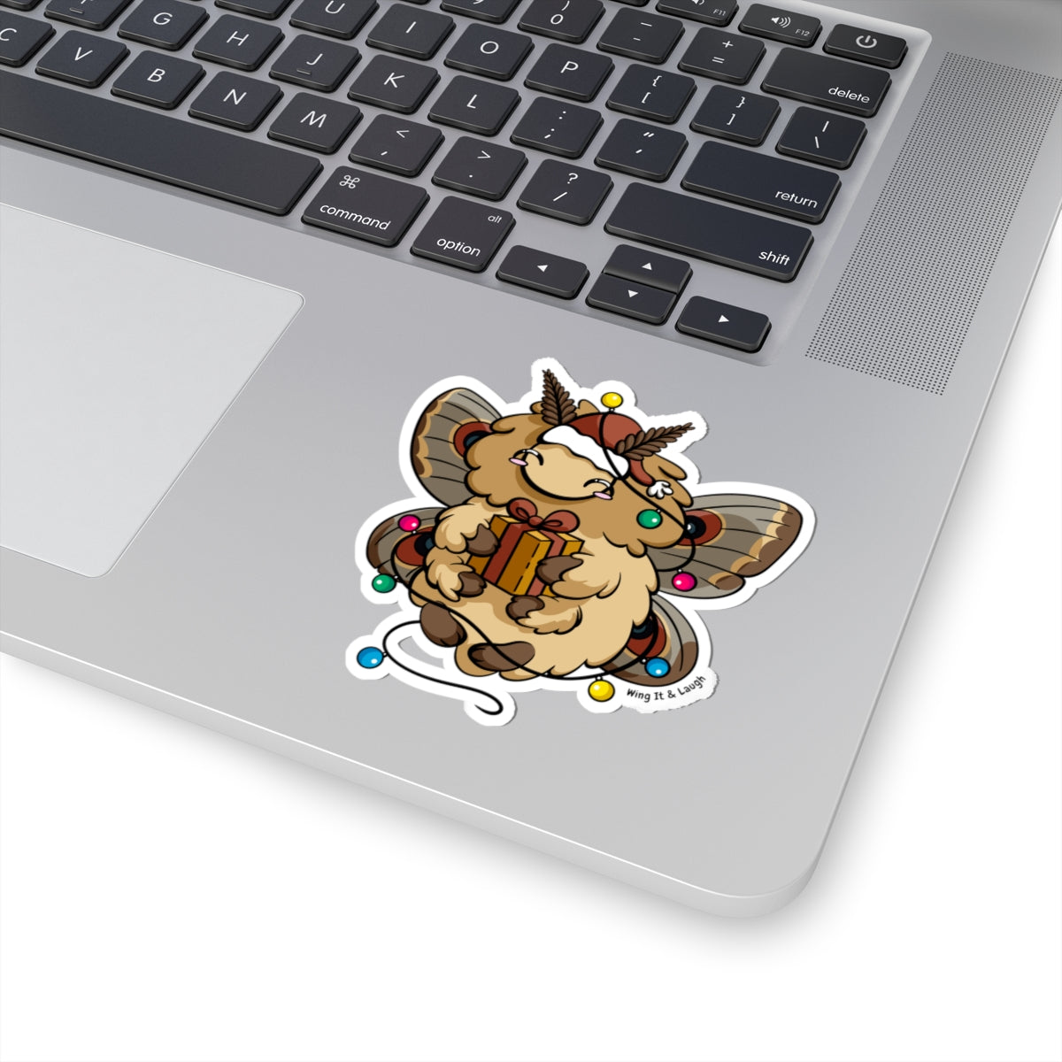 Laptop with a cute holiday moth with Christmas lights sticker on the palm rest area.