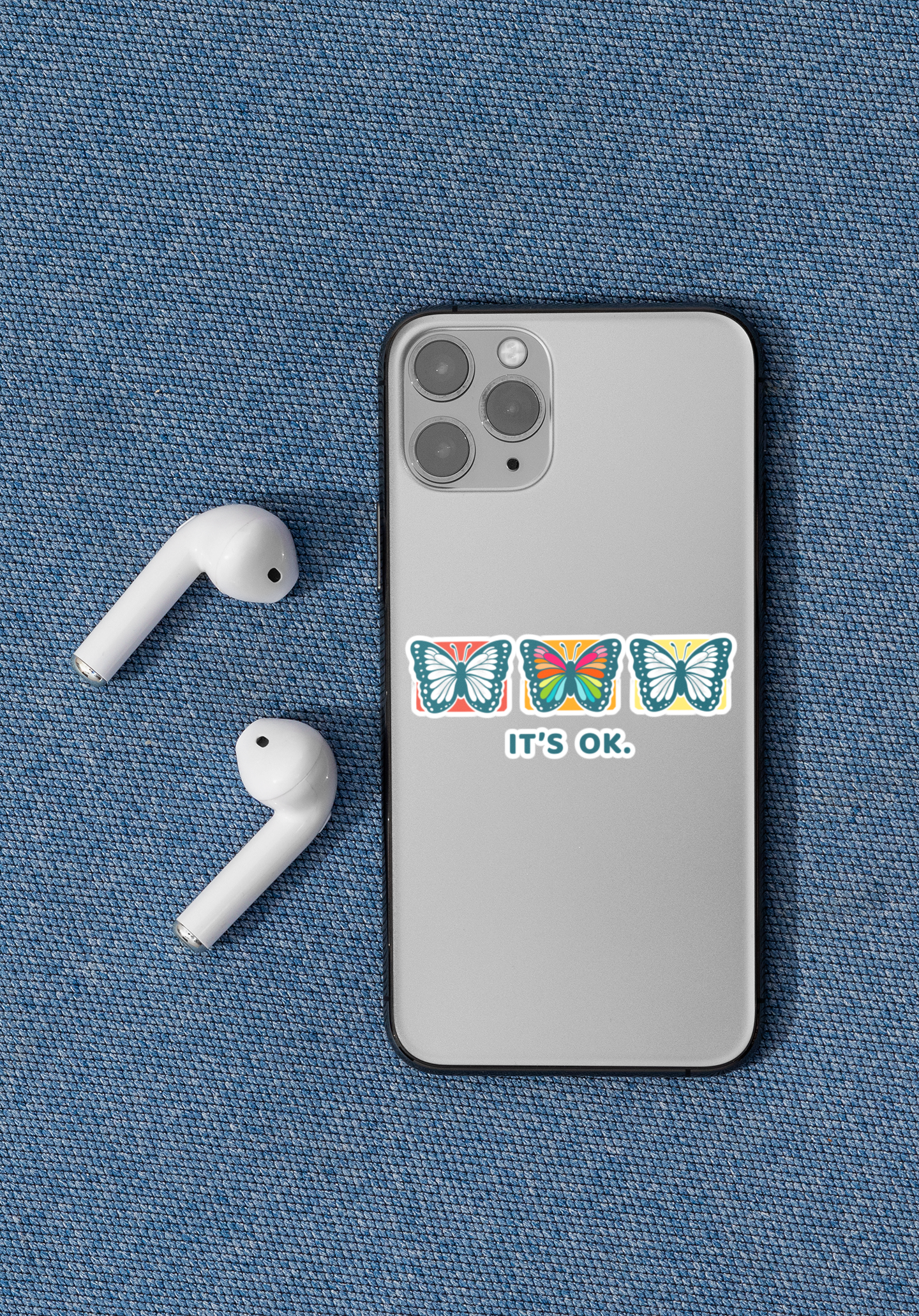 a 'it's ok' butterfly sticker placed on an iphone 11 pro