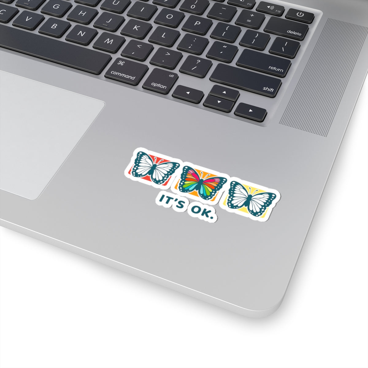 'it's ok' affirmation sticker on a laptop near the keyboard, glossy finish