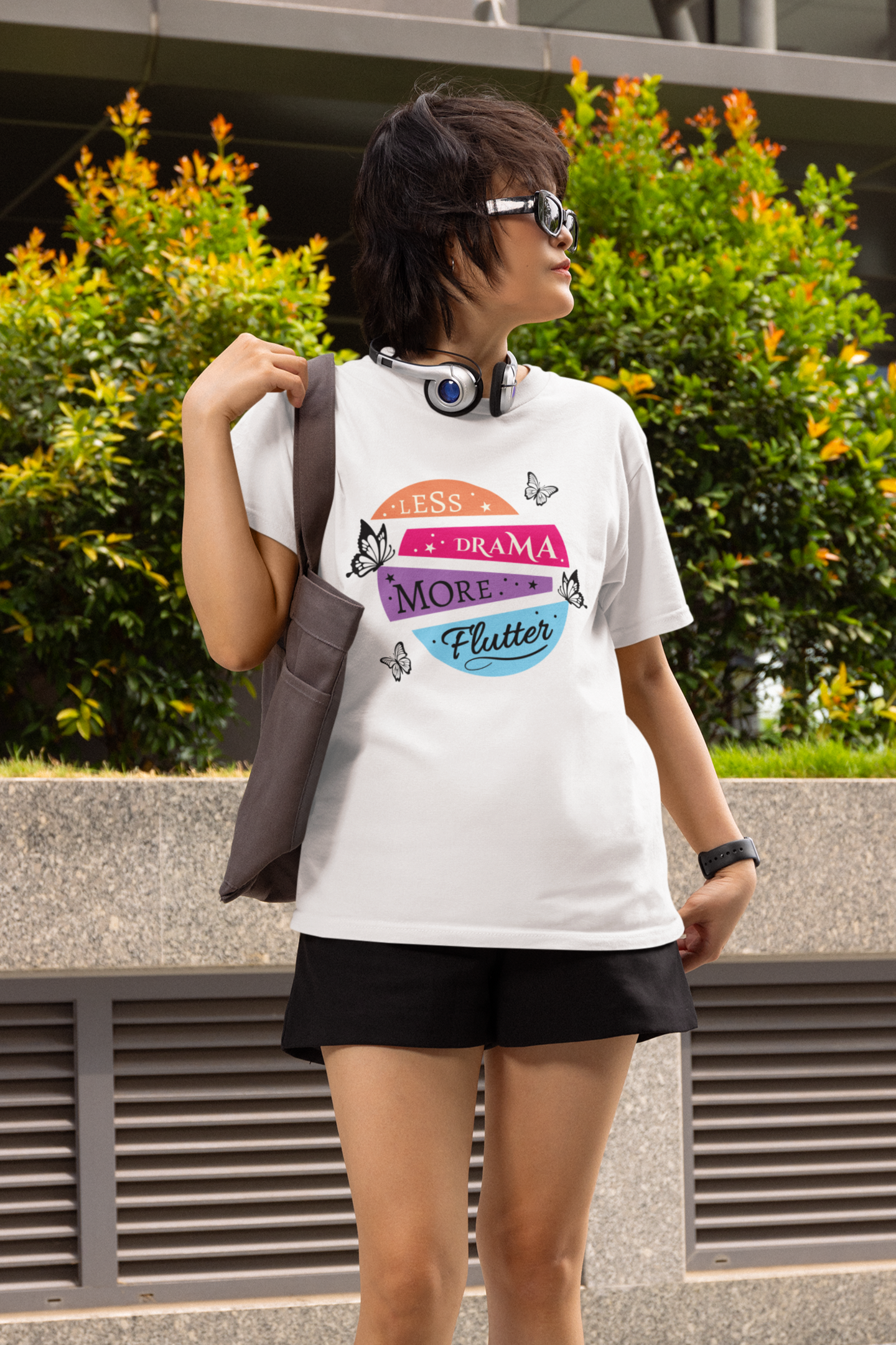 woman with retro headphones and glasses wearing black “less drama more flutter” butterfly t-shirt