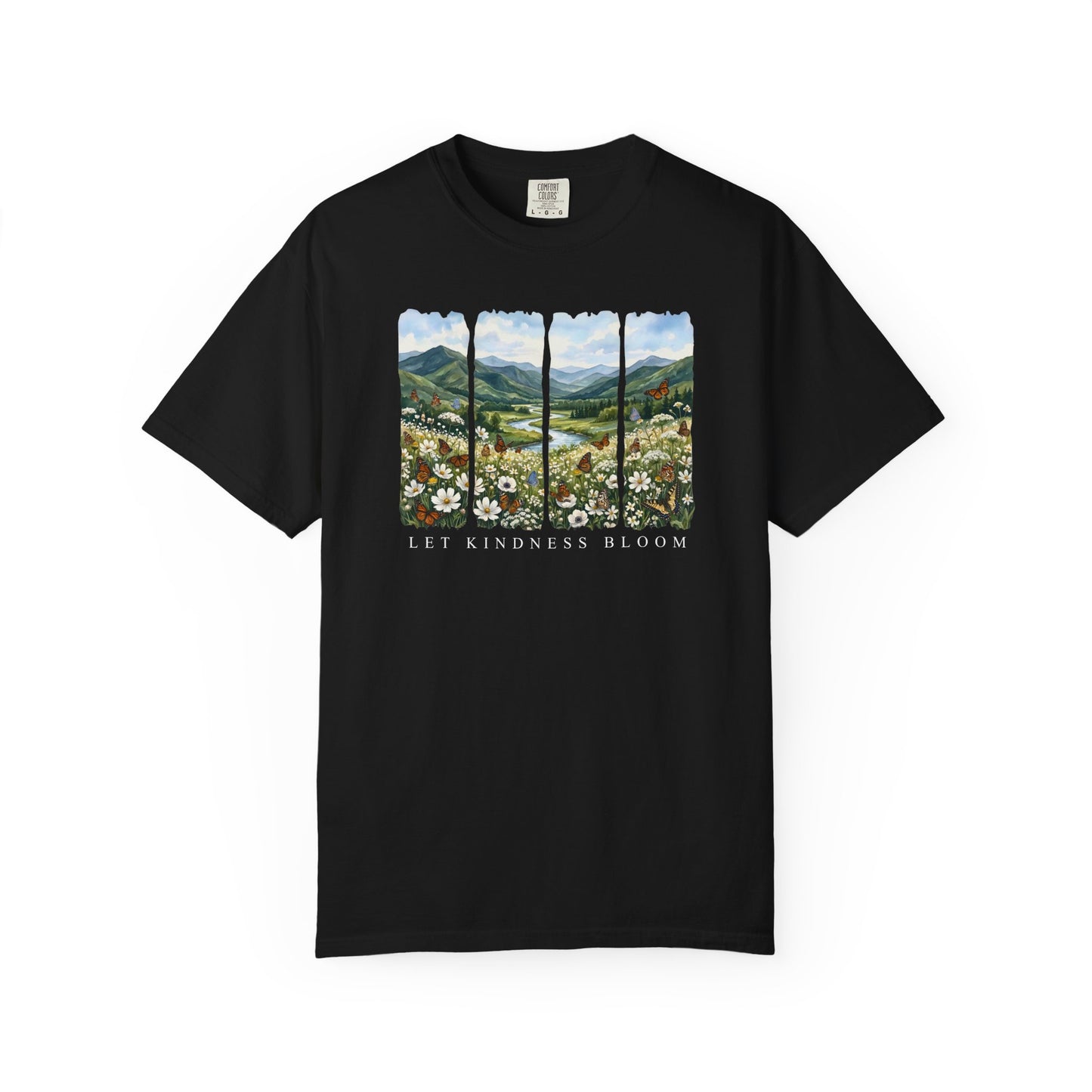 Black unisex garment-dyed t-shirt featuring a floral mountain landscape with butterflies and the phrase Let Kindness Bloom on a white background