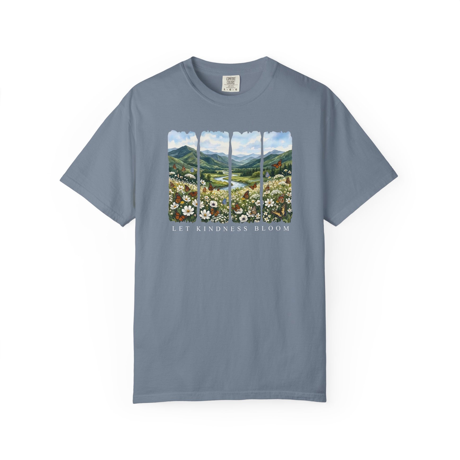 Blue Let Kindness Bloom t-shirt featuring floral butterfly landscape artwork and inspirational text on a white background