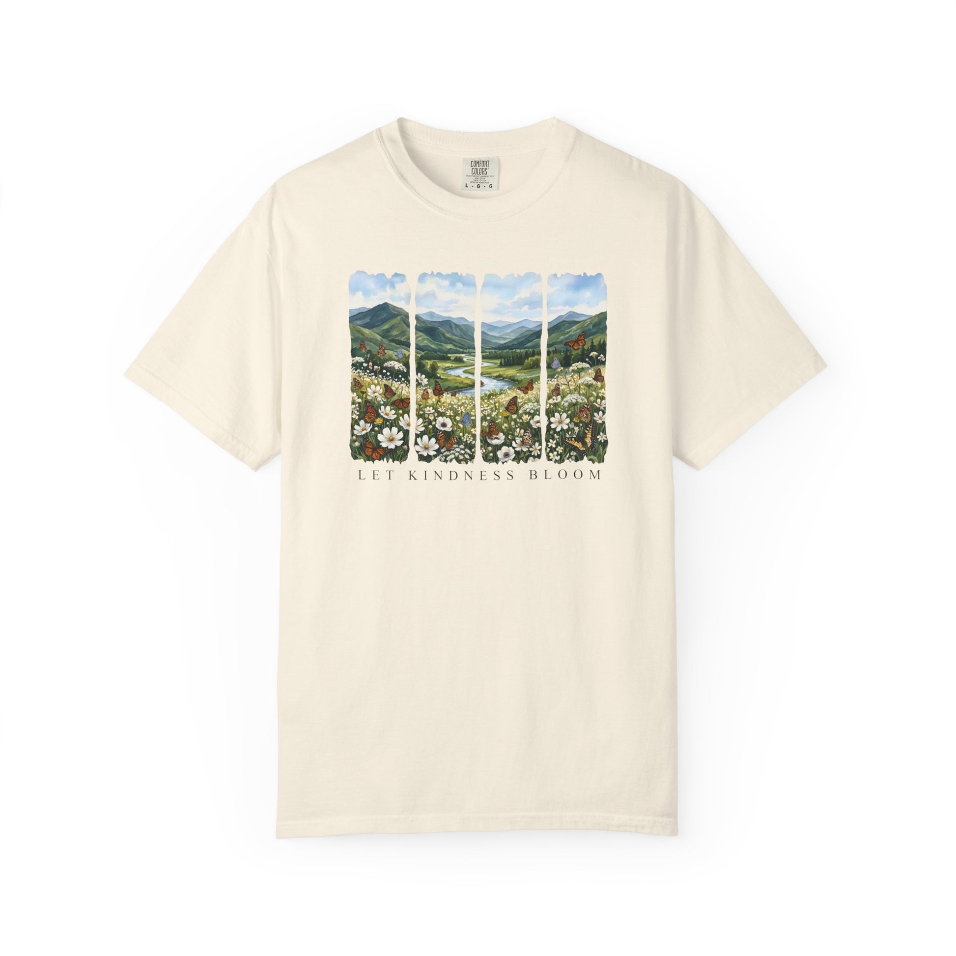 Cream t-shirt featuring a Let Kindness Bloom butterfly floral landscape graphic on the chest on a white background