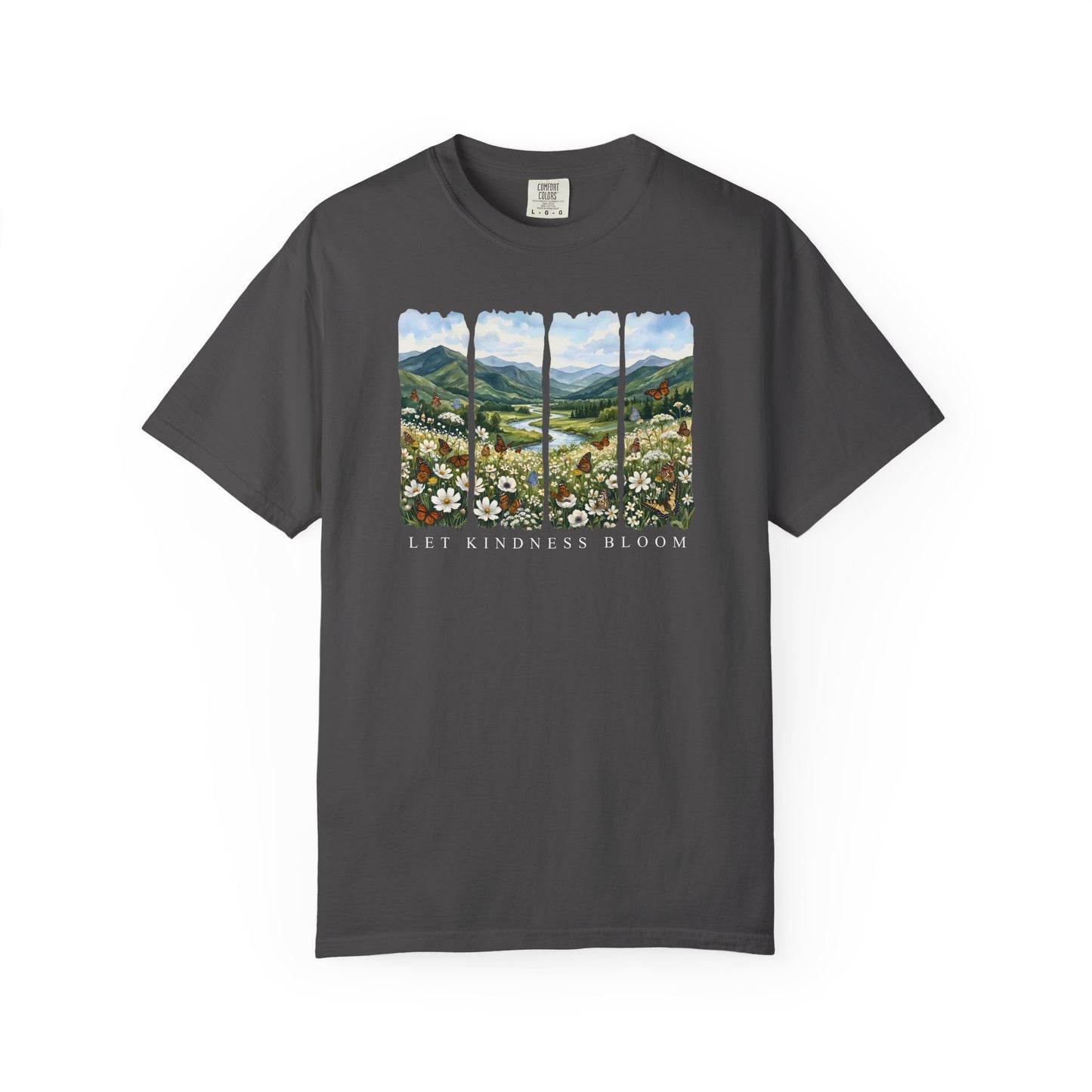 Dark gray garment-dyed Let Kindness Bloom t-shirt with floral meadow, butterflies, and mountain landscape artwork on a white background