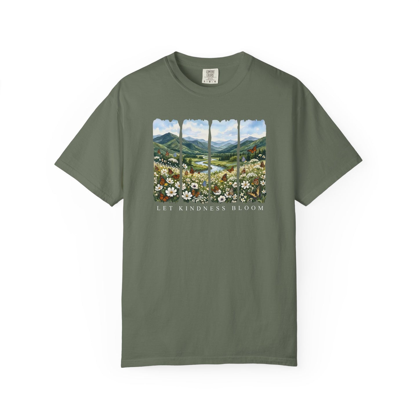 Green Let Kindness Bloom t-shirt with butterflies, wildflowers, and scenic mountain landscape illustration on a white background