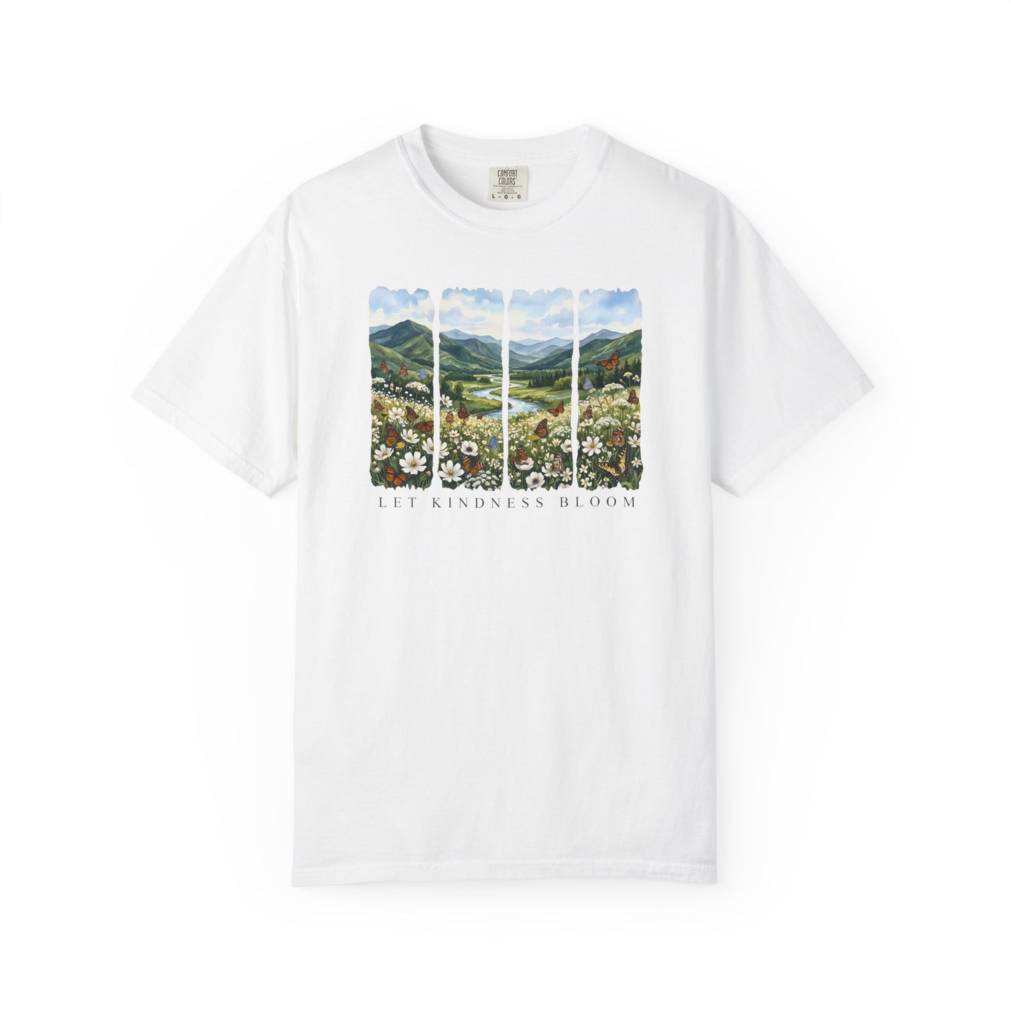 White t-shirt with Let Kindness Bloom floral landscape and butterfly design shown on a white background