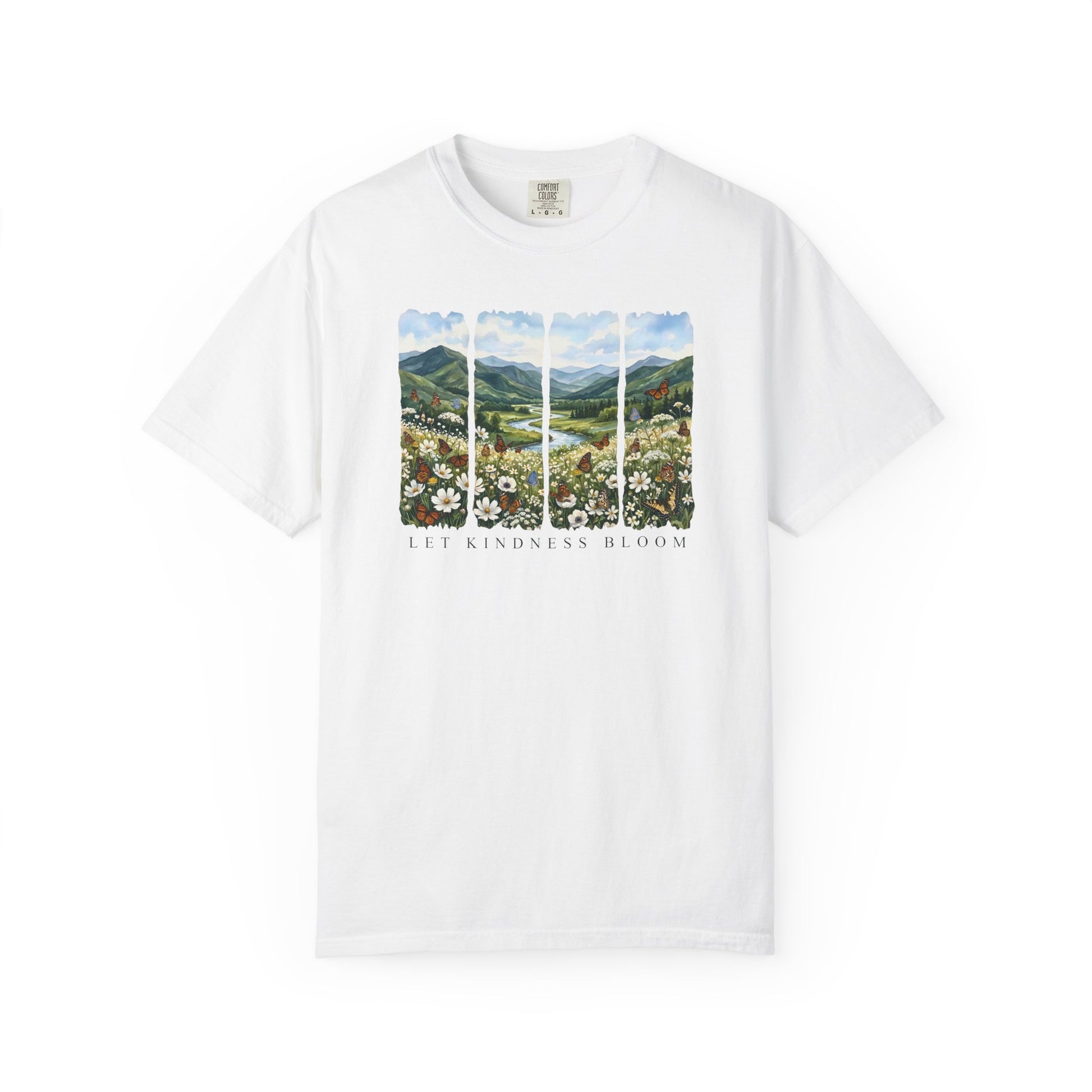 White t-shirt with Let Kindness Bloom floral landscape and butterfly design shown on a white background