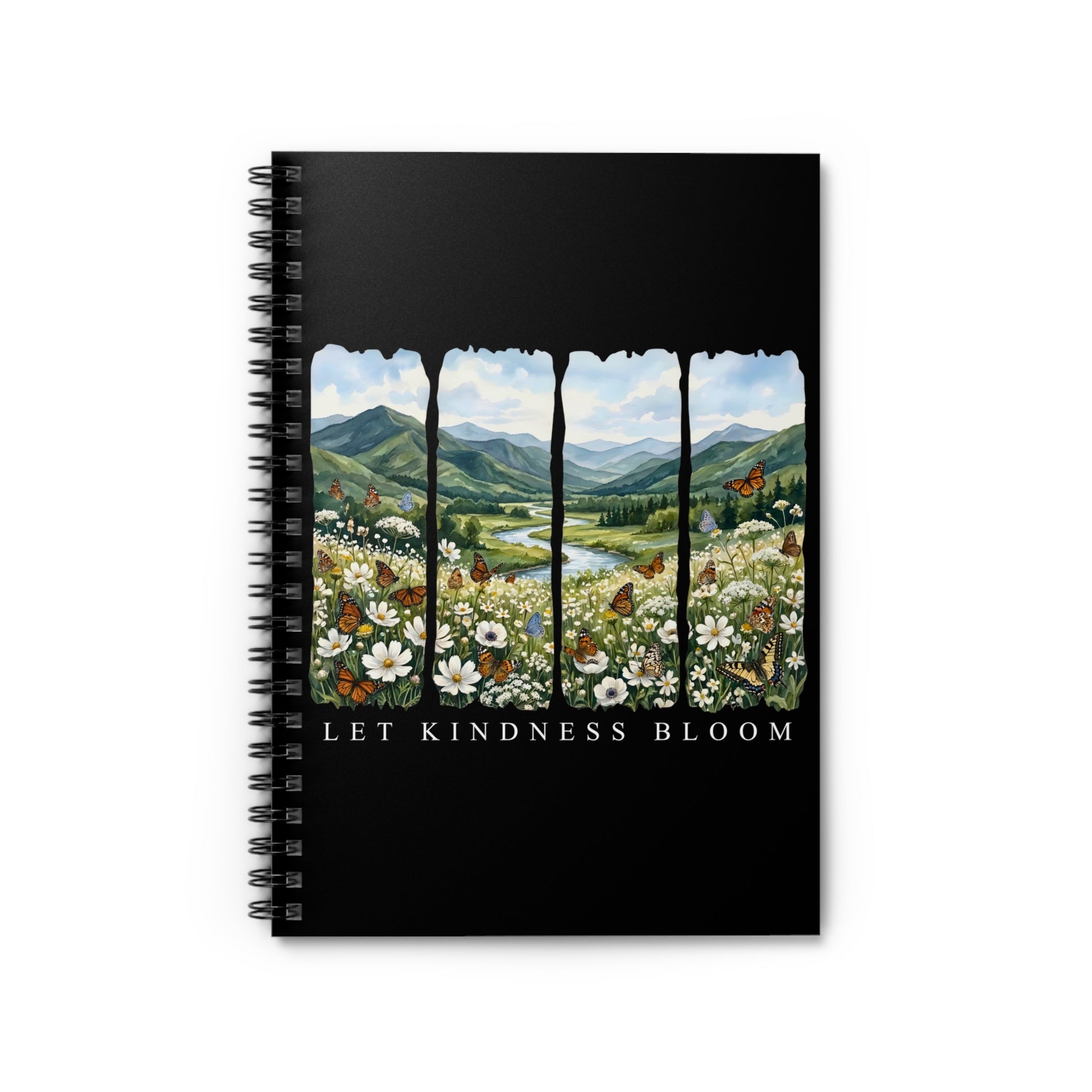 Black spiral notebook featuring a floral mountain landscape with butterflies and the phrase Let Kindness Bloom on the cover on a black background