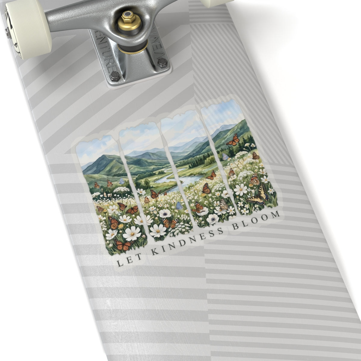 Skateboard with a Let Kindness Bloom butterfly landscape sticker on a white background