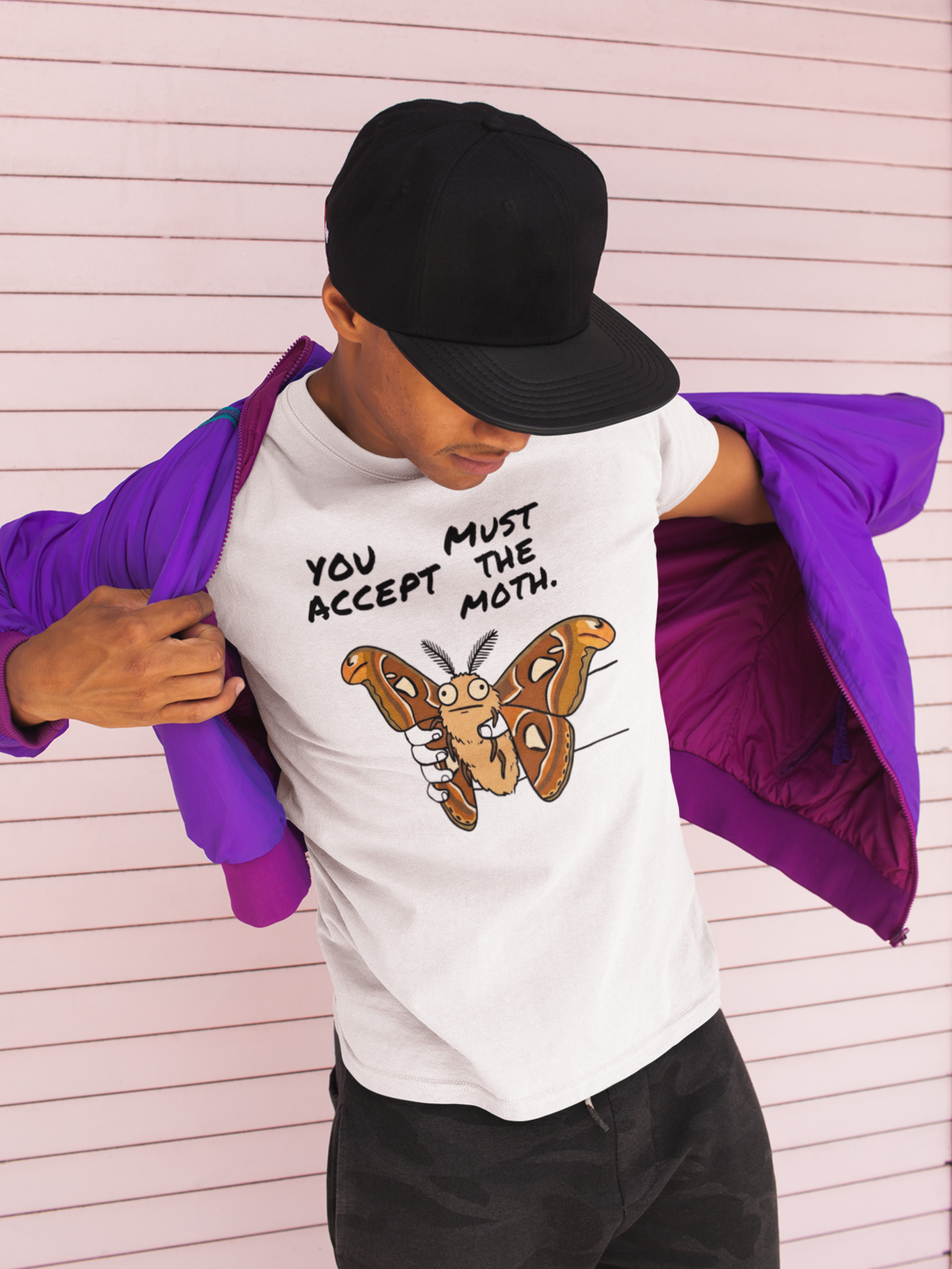 Man wearing white Atlas Moth graphic t-shirt featuring You Must Accept The Moth internet humor artwork.