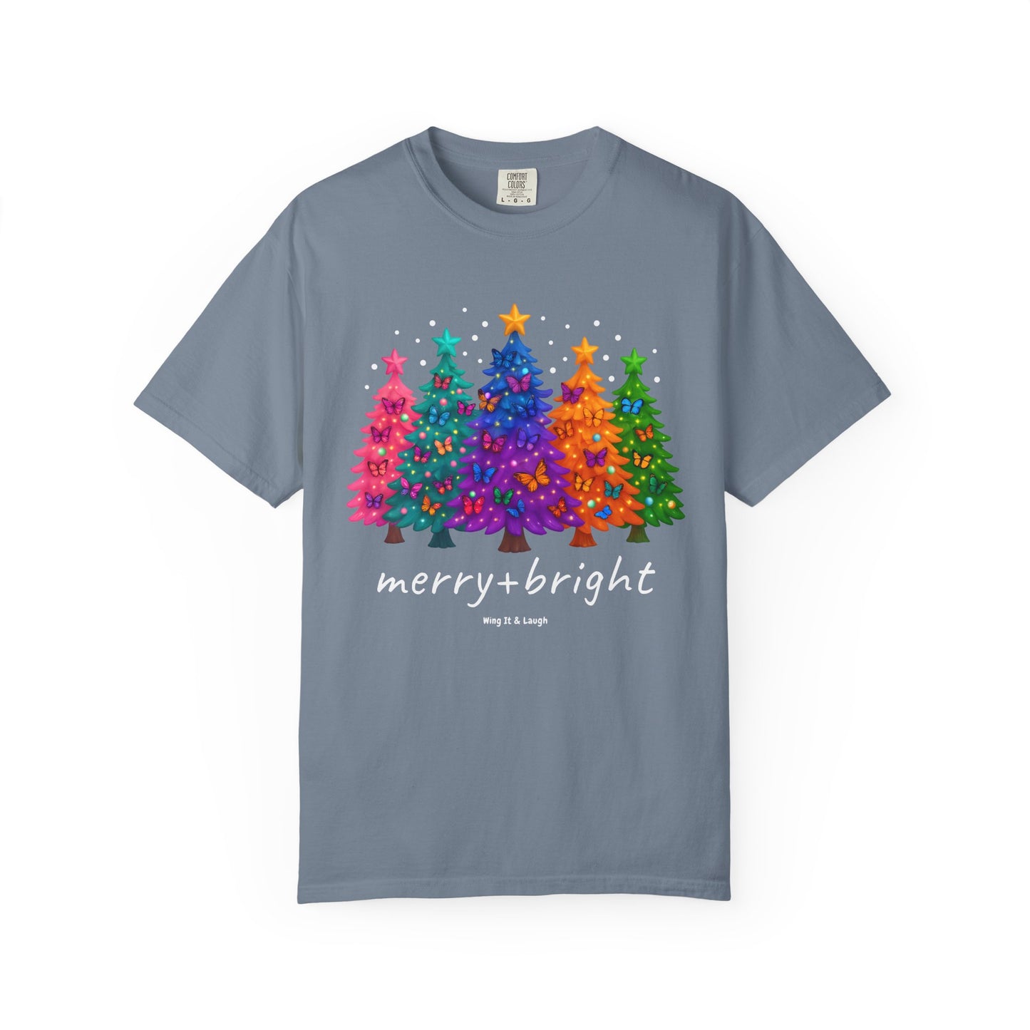 Blue t-shirt with colorful stars and christmas trees design and 'merry and bright' text on a white background.
