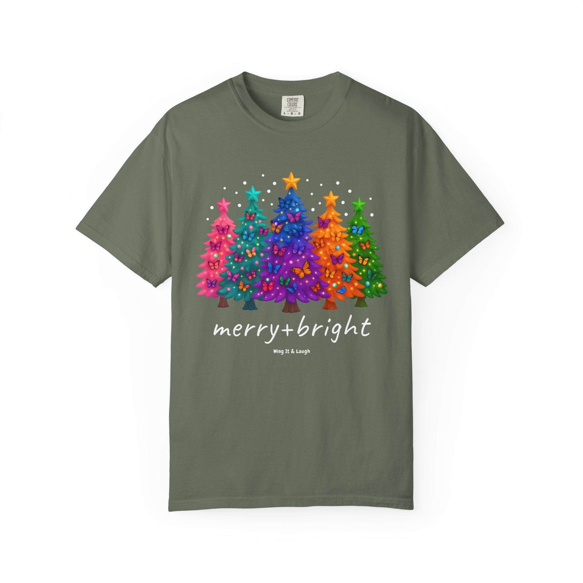 Green t-shirt with colorful stars and christmas trees design and 'merry and bright' text on a white background.