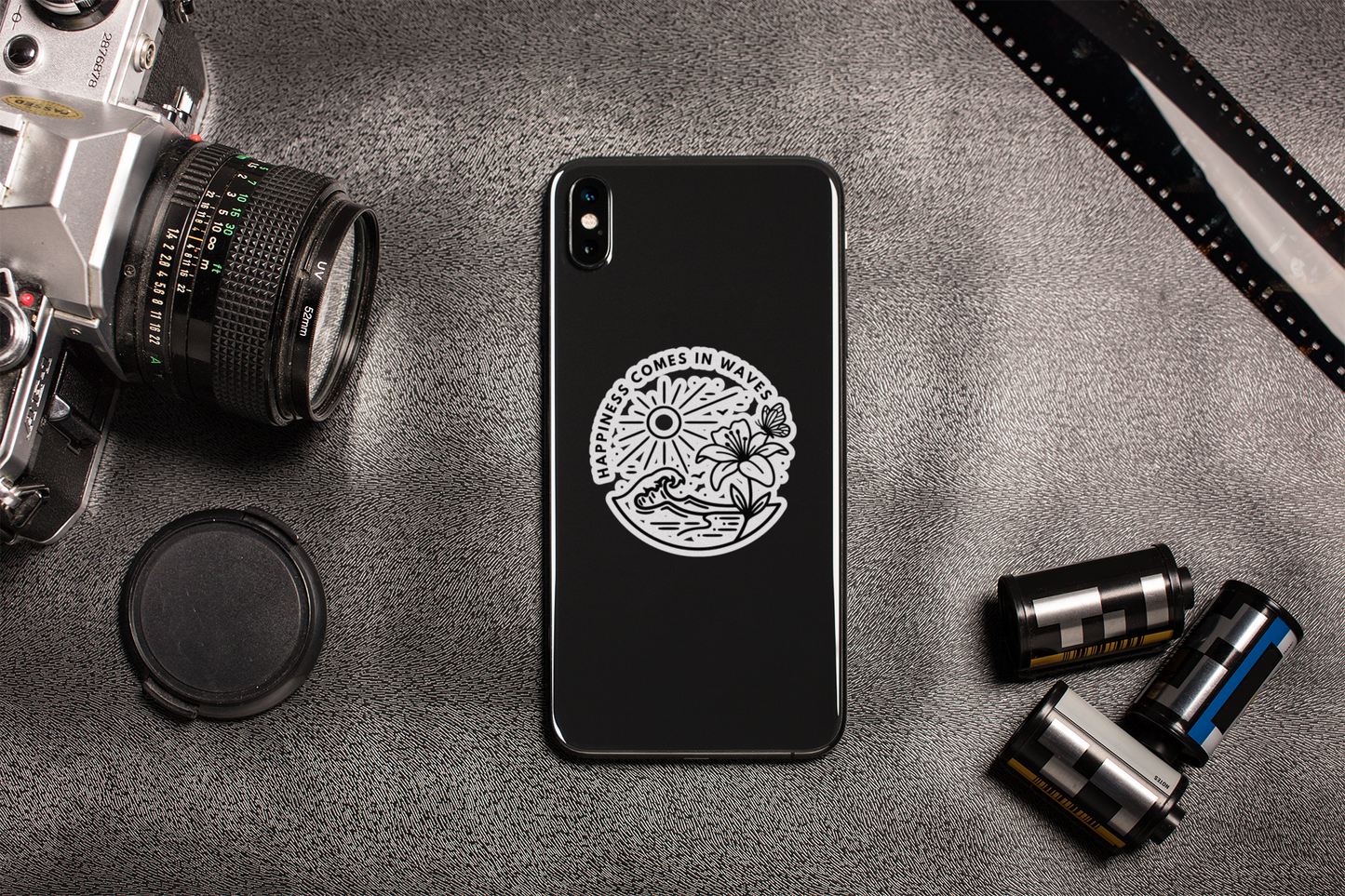 Happiness Comes in Waves beach butterfly sticker applied to phone in lifestyle flat lay