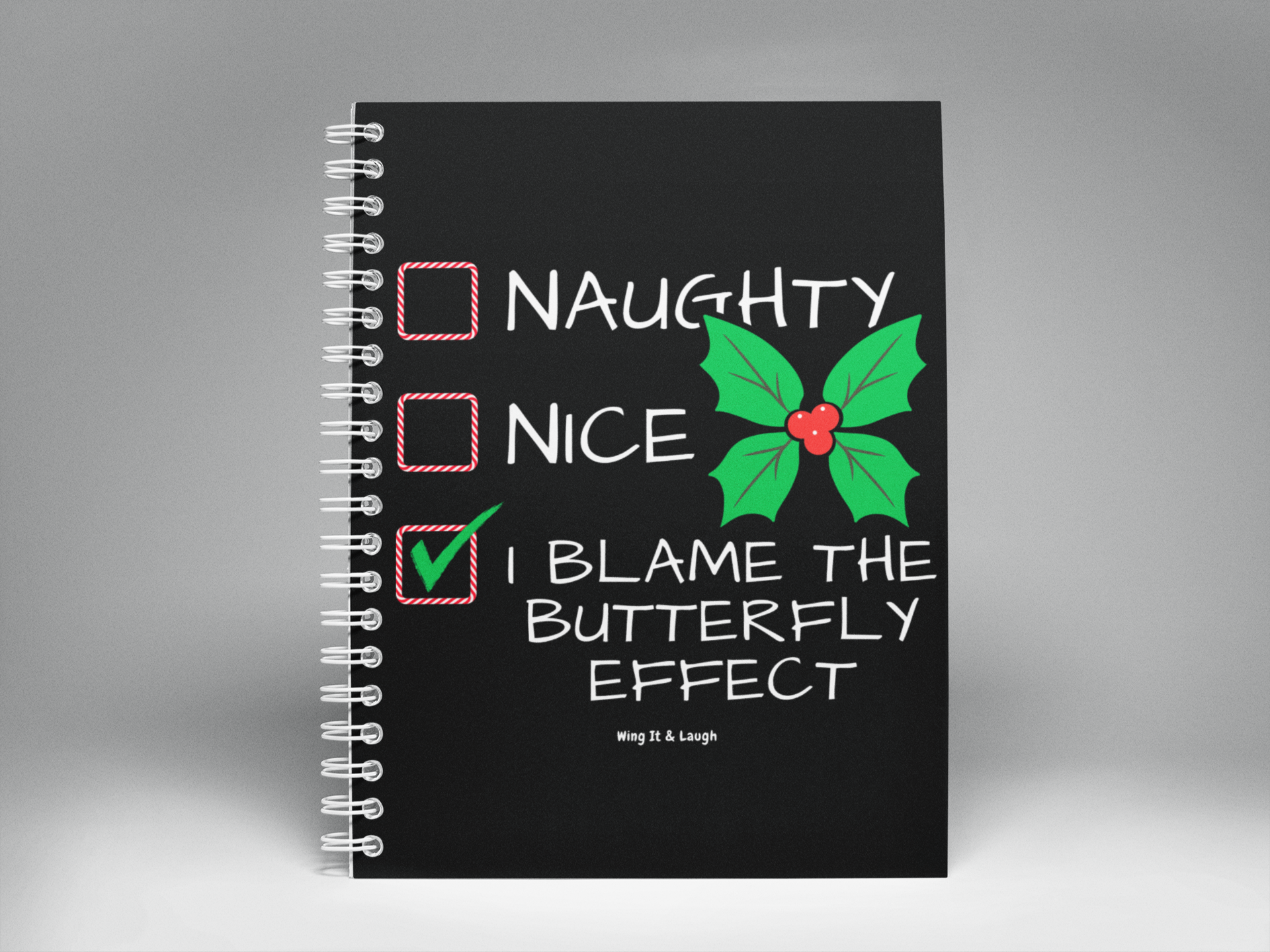 Black notebook with Naughty or nice Christmas checklist on a gray background spiral notebook