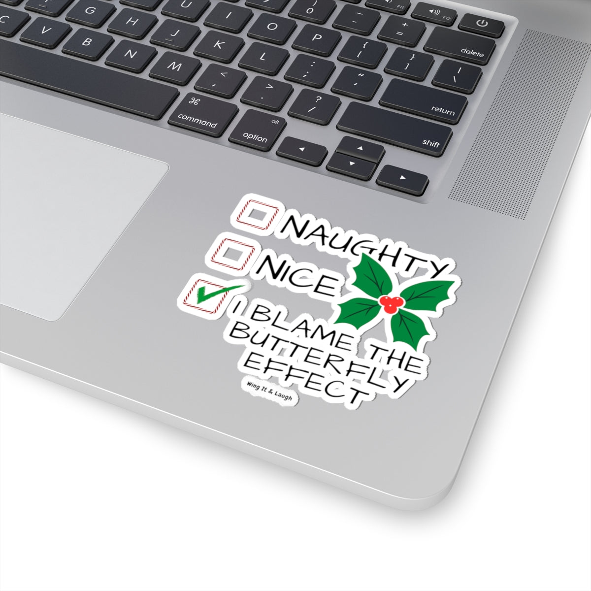 Laptop with naughty or nice butterfly effect Christmas vinyl sticker on the palm rest area.