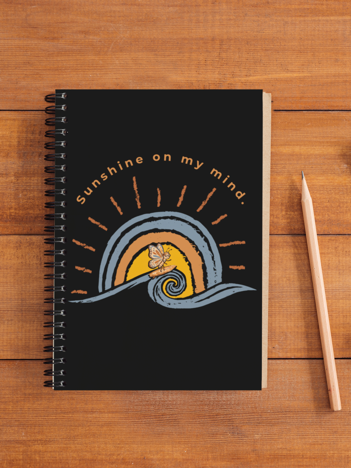 Sunshine On My Mind butterfly spiral notebook on wooden desk with pencil and retro beach-inspired butterfly artwork